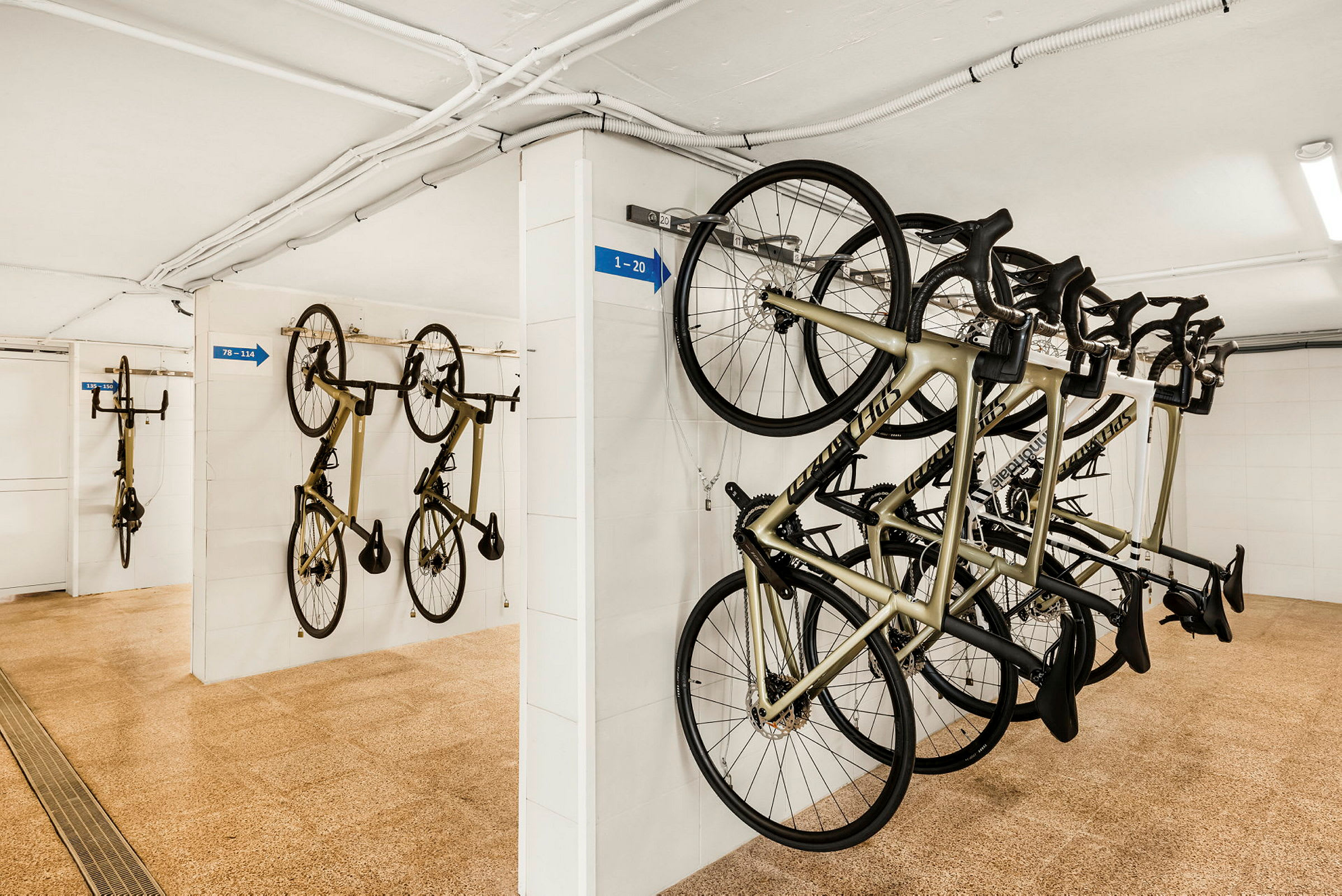 En cykelförvaringsplats med flera upphängda cyklar, tydligt organiserade (AI-genererad text)