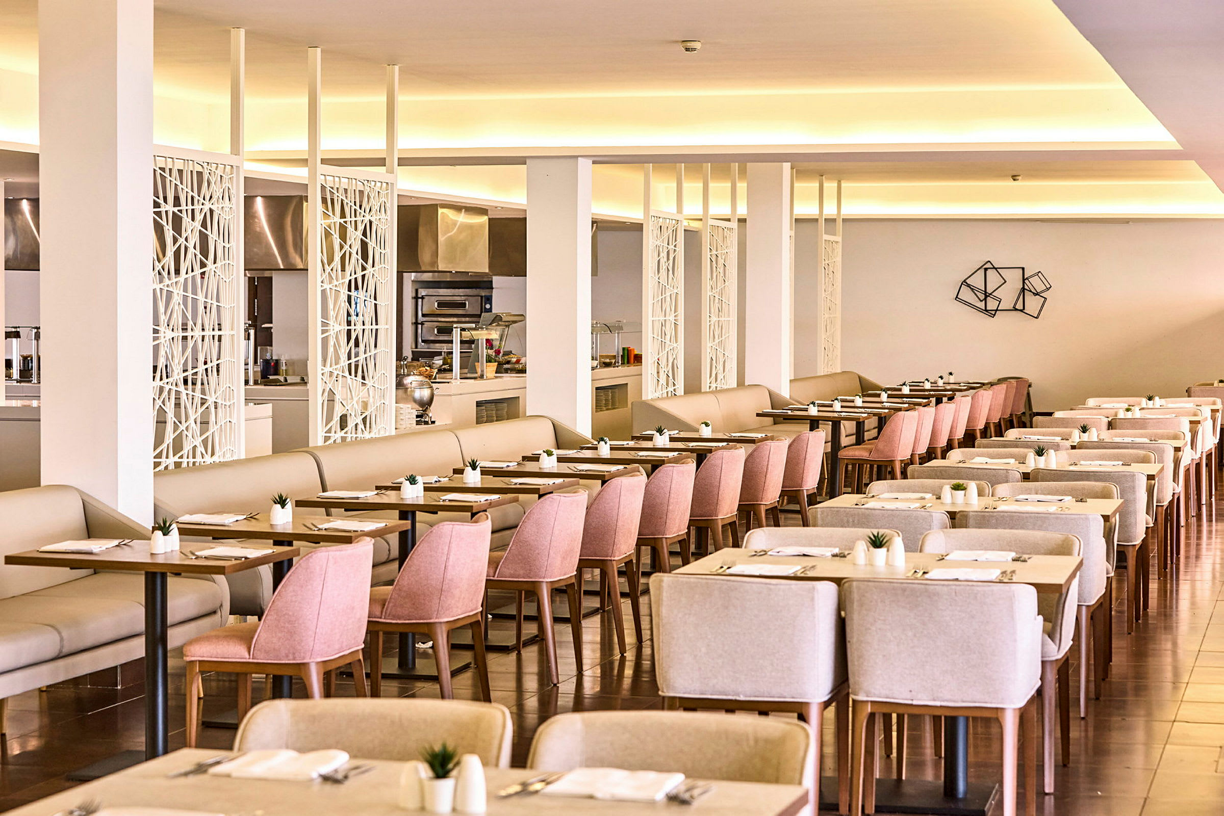 Ett rymligt hotellrestaurangområde med ljus inredning och välordnade bord och stolar. (AI-genererad text)