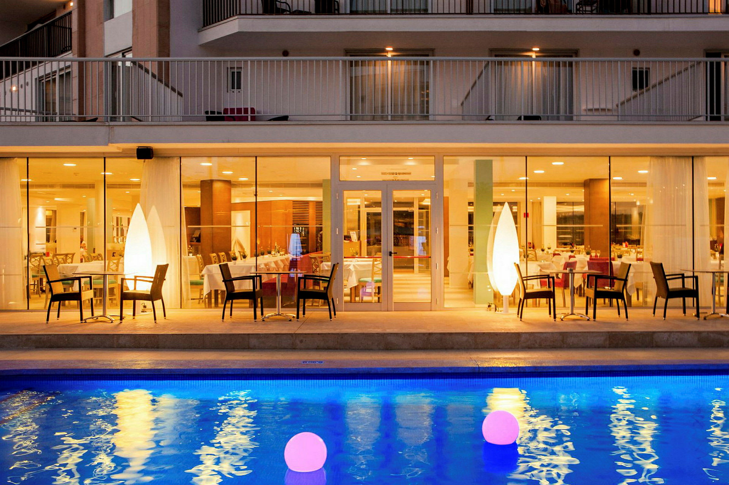 Hotellrestaurang med upplyst pool i förgrunden. (AI-genererad text)