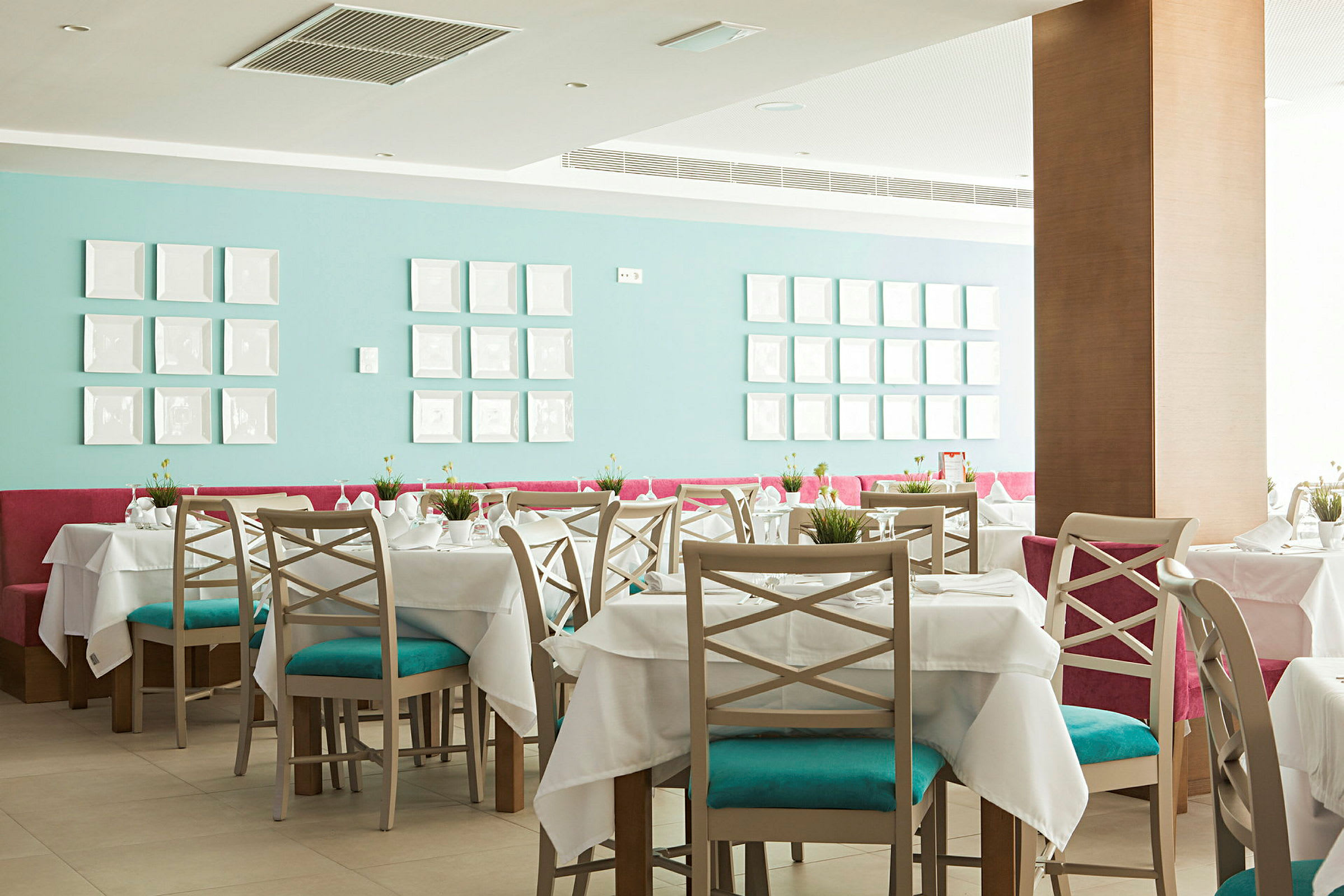 Restaurang med dukade bord och färgstark inredning. (AI-genererad text)