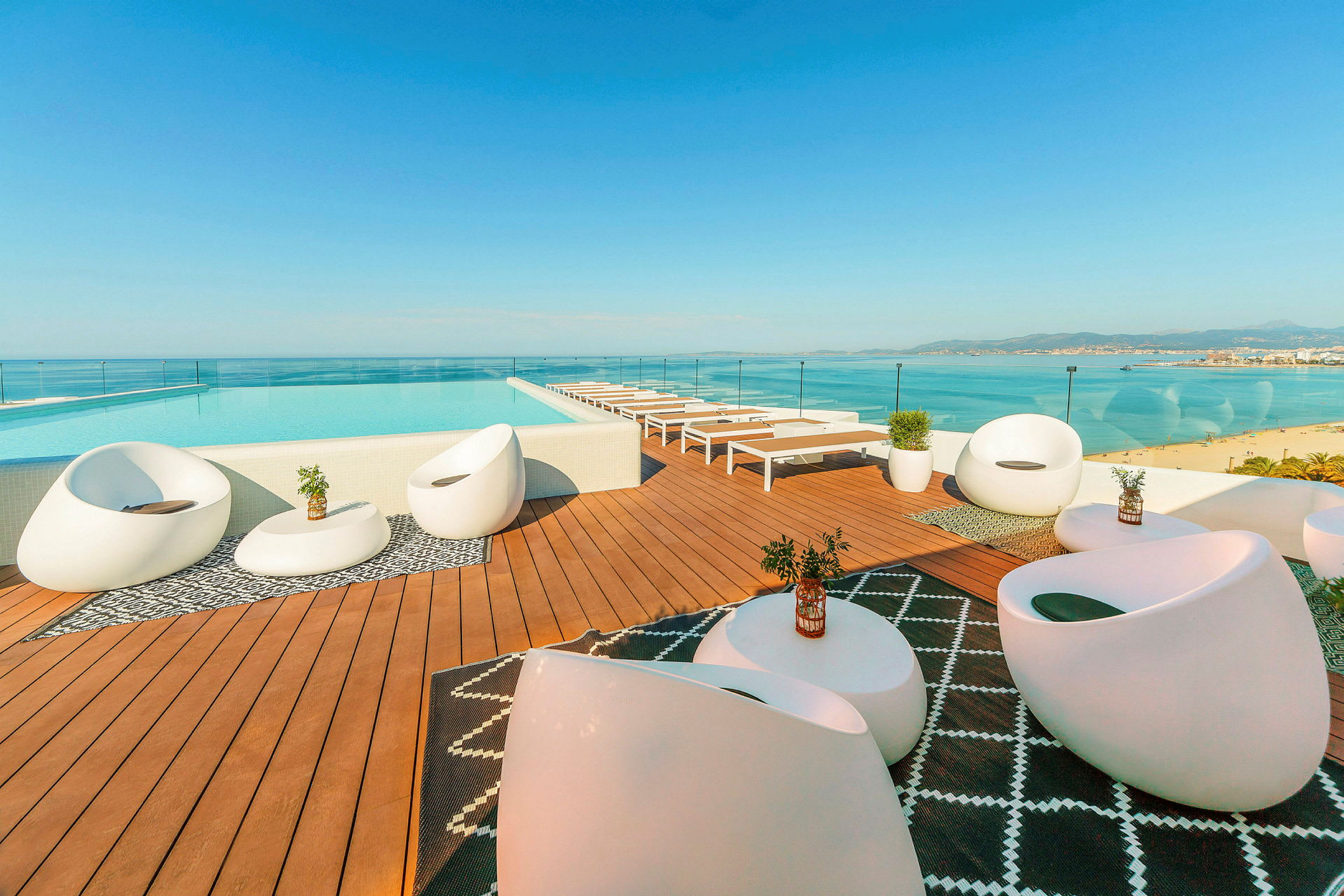 En takterrass med pool, solstolar och moderna möbler med utsikt över havet. (AI-genererad text)