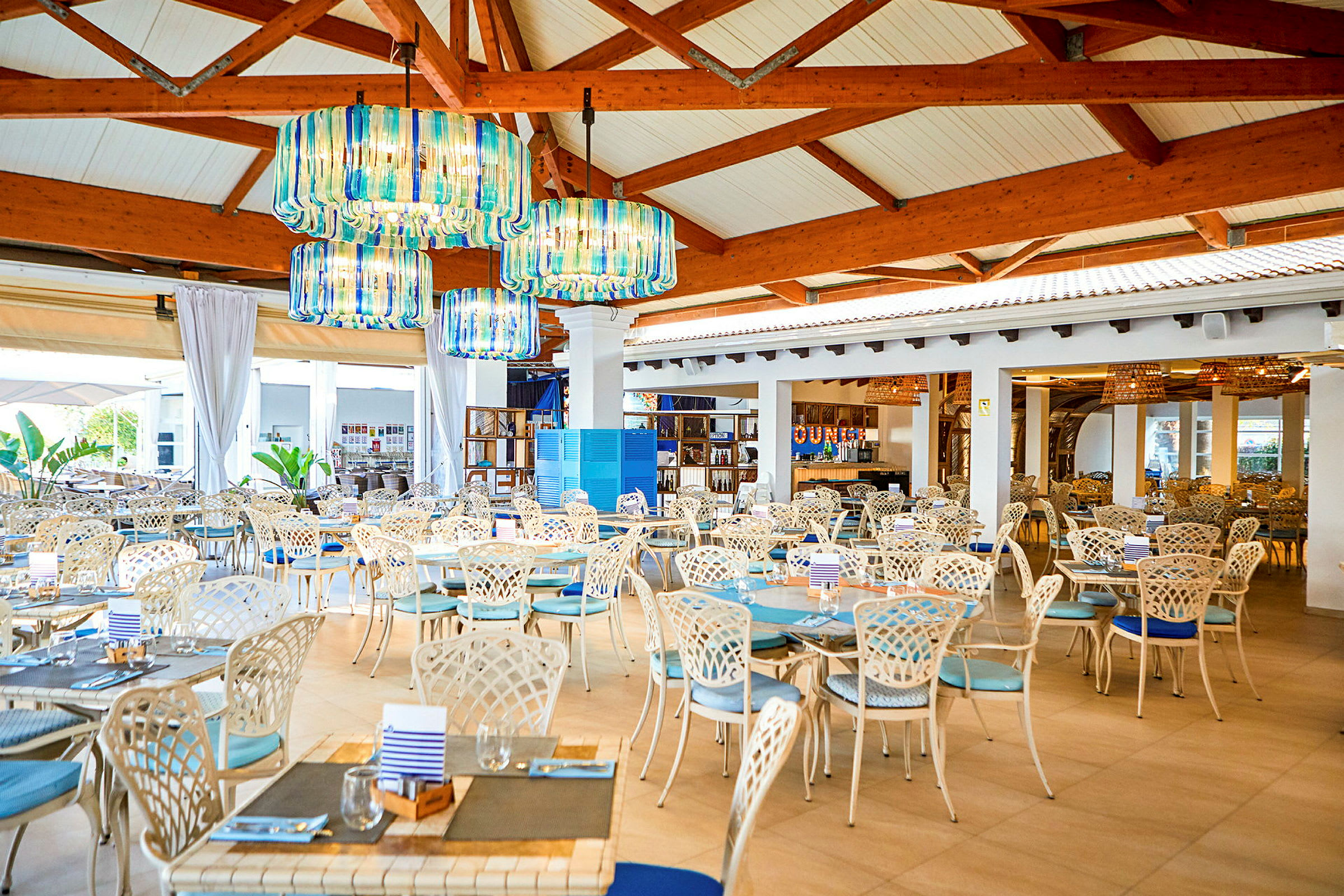 En restaurang med bordsuppsättningar och färgglada lampor. (AI-genererad text)