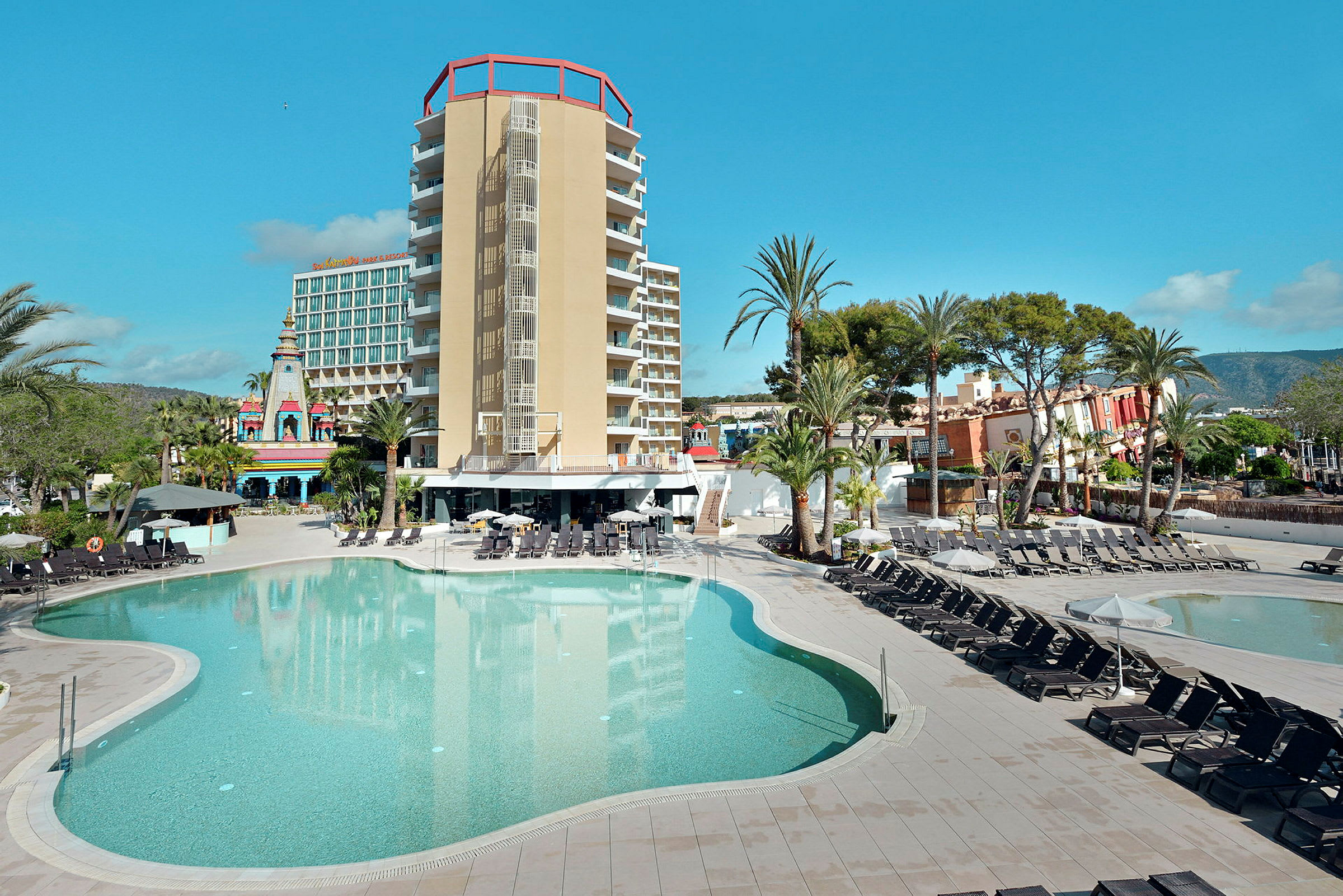 Poolområde med solstolar och en modern hotellbyggnad i bakgrunden. (AI-genererad text)