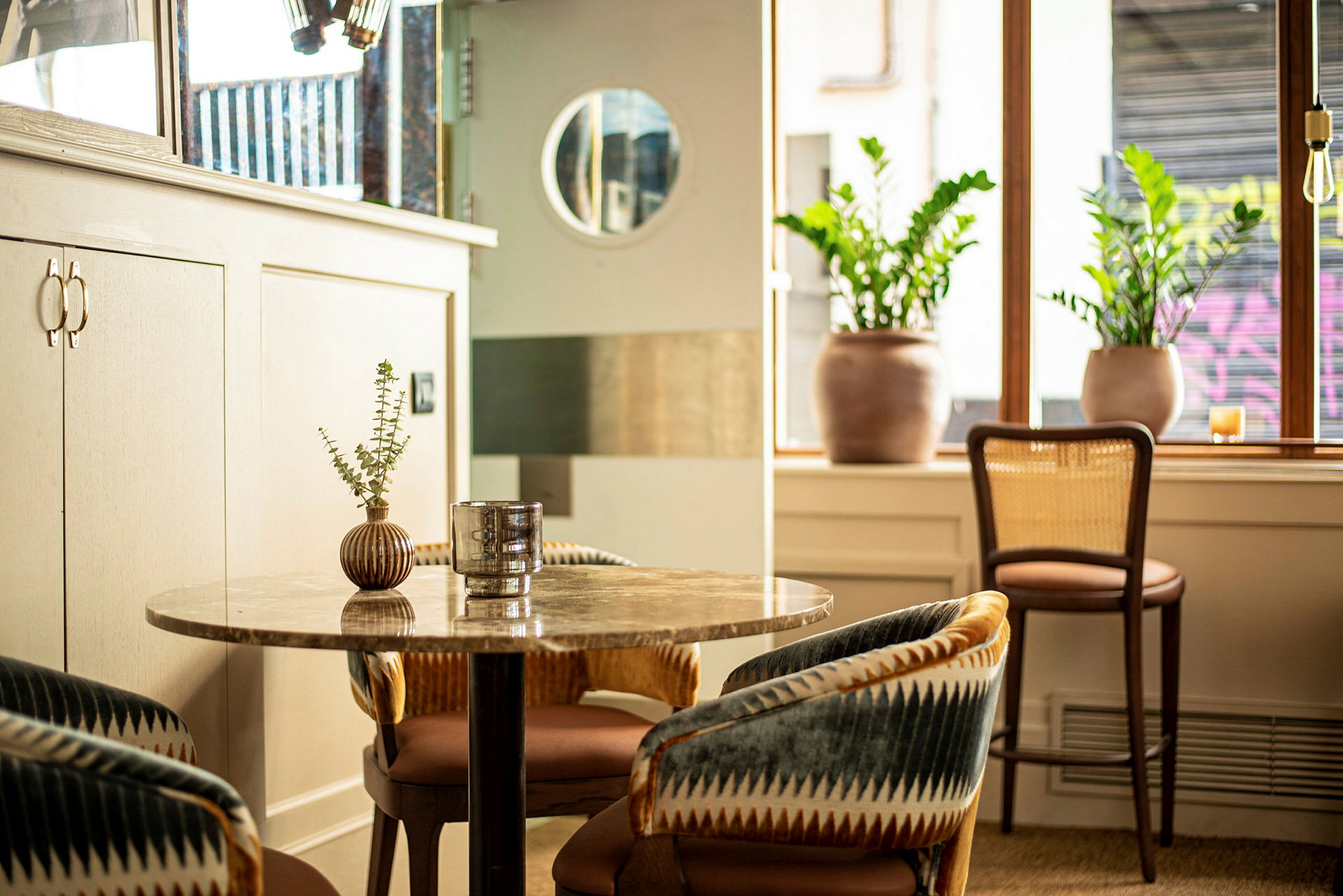 Ett modernt café med loungestolar, ett bord och växter. (AI-genererad text)