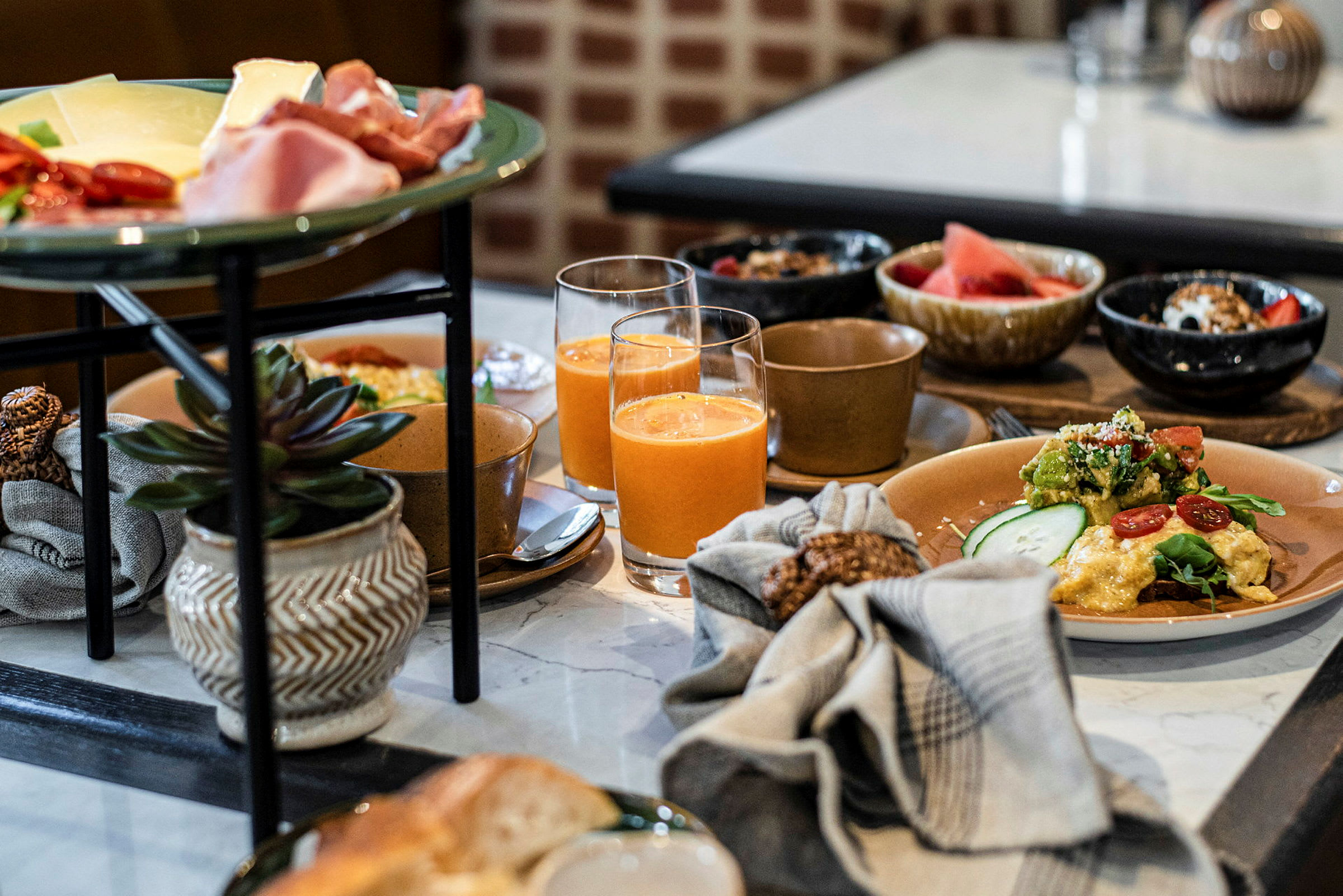 En frukostbuffé med olika rätter och drycker på ett bord. (AI-genererad text)