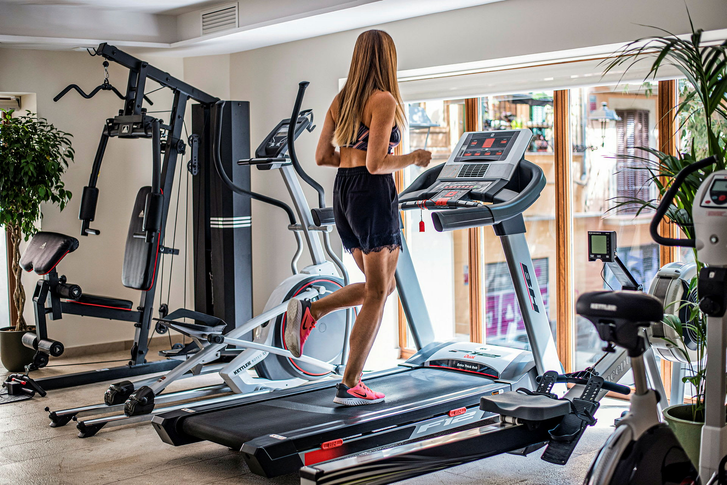 En kvinna springer på ett löpband i ett gym. (AI-genererad text)