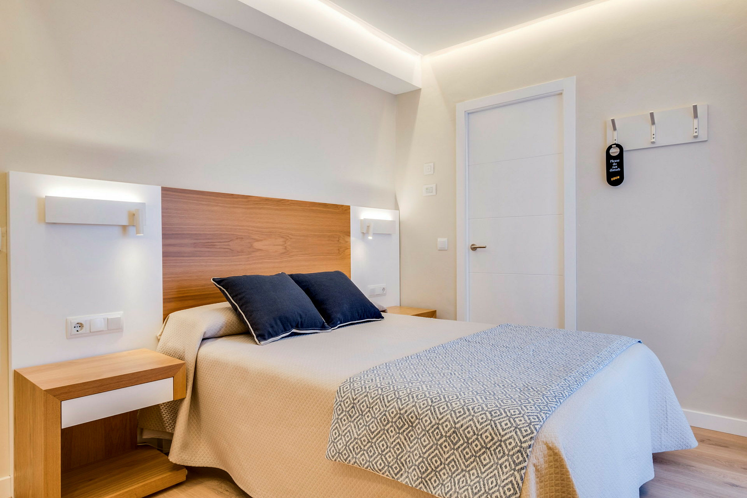 Ett hotellrum med en säng och två kuddar. (AI-genererad text)