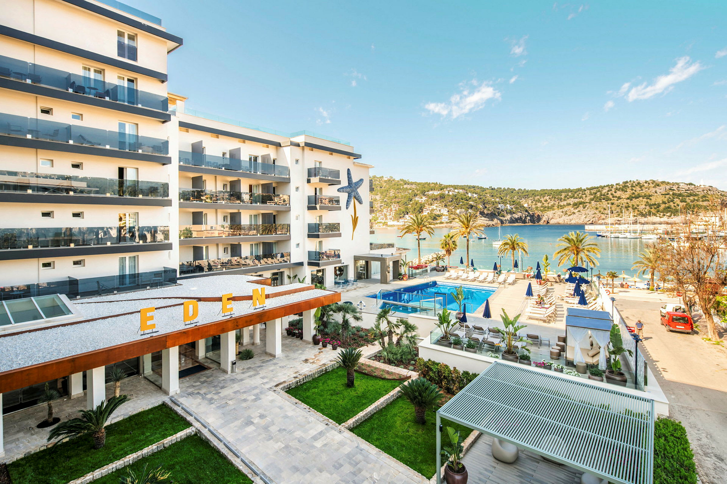 Hotellbyggnad med balkonger och en pool i närheten av havet. (AI-genererad text)