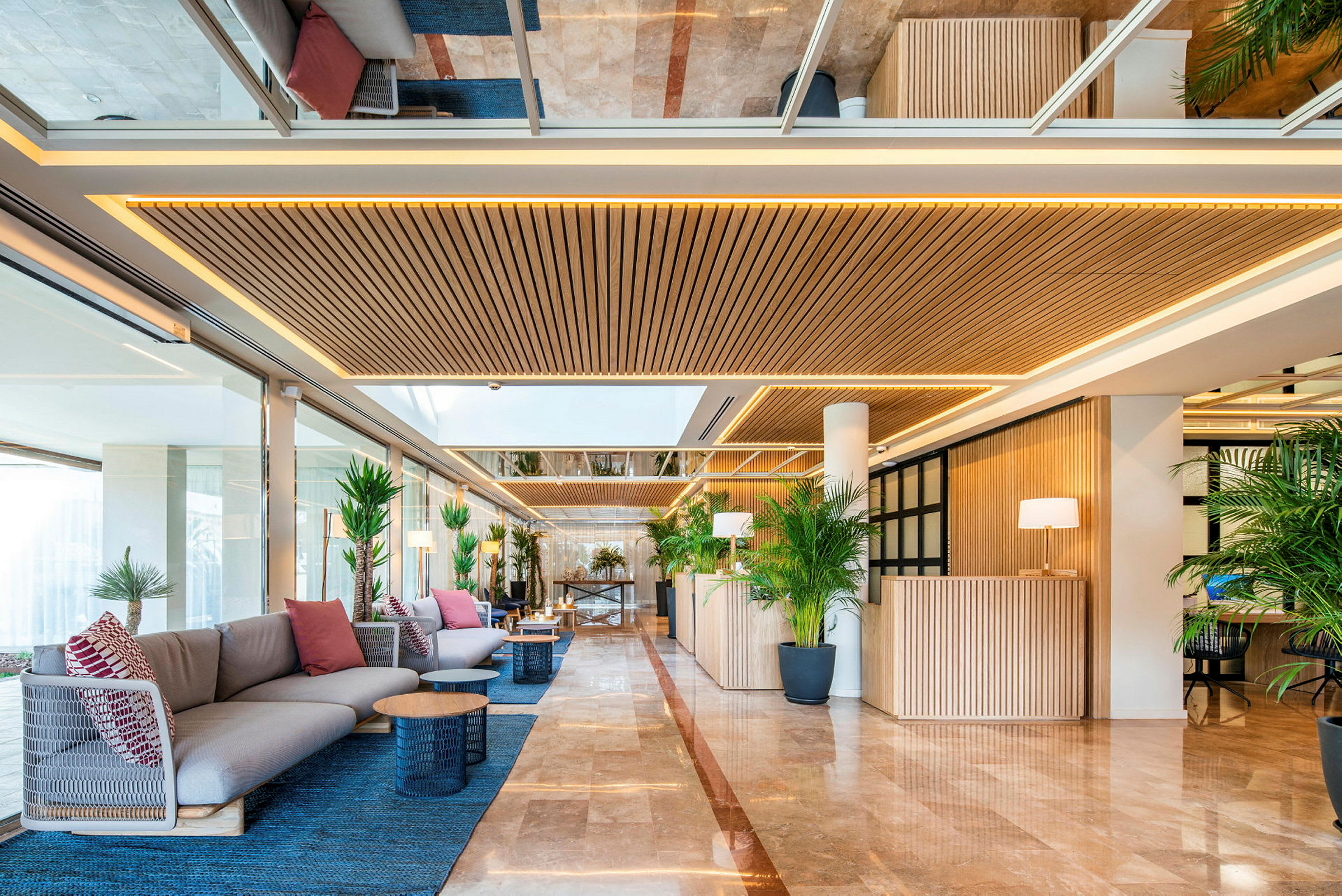 En hotellobby med sittmöbler, växter och träpaneler. (AI-genererad text)