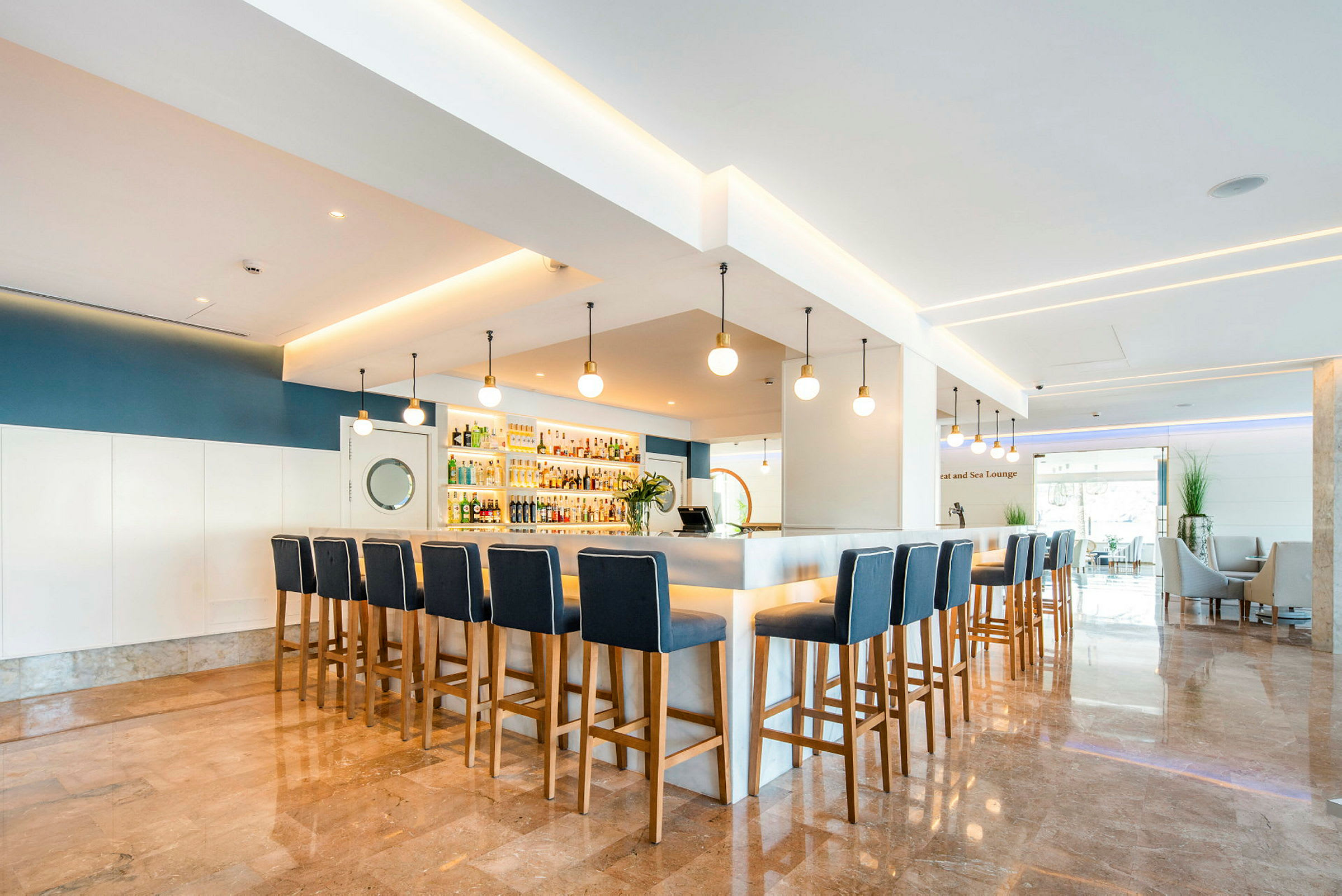 Bild av en modern bar med höga stolar runt en bardisk och snygg belysning. (AI-genererad text)