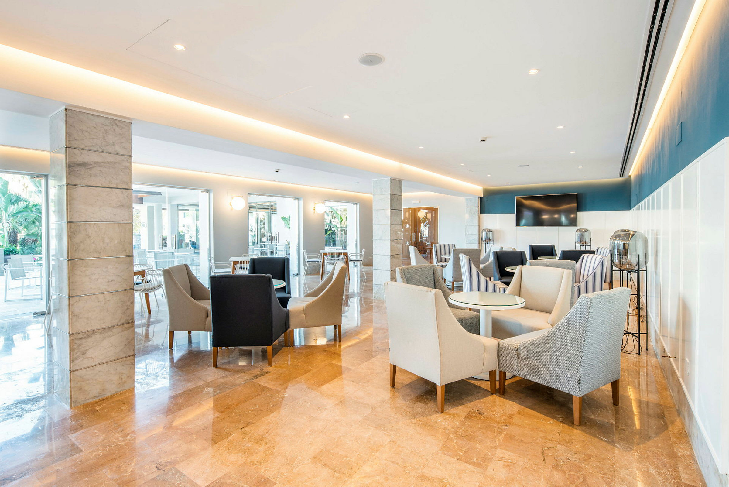 En ljus och modern lounge med soffstolar och bord. (AI-genererad text)