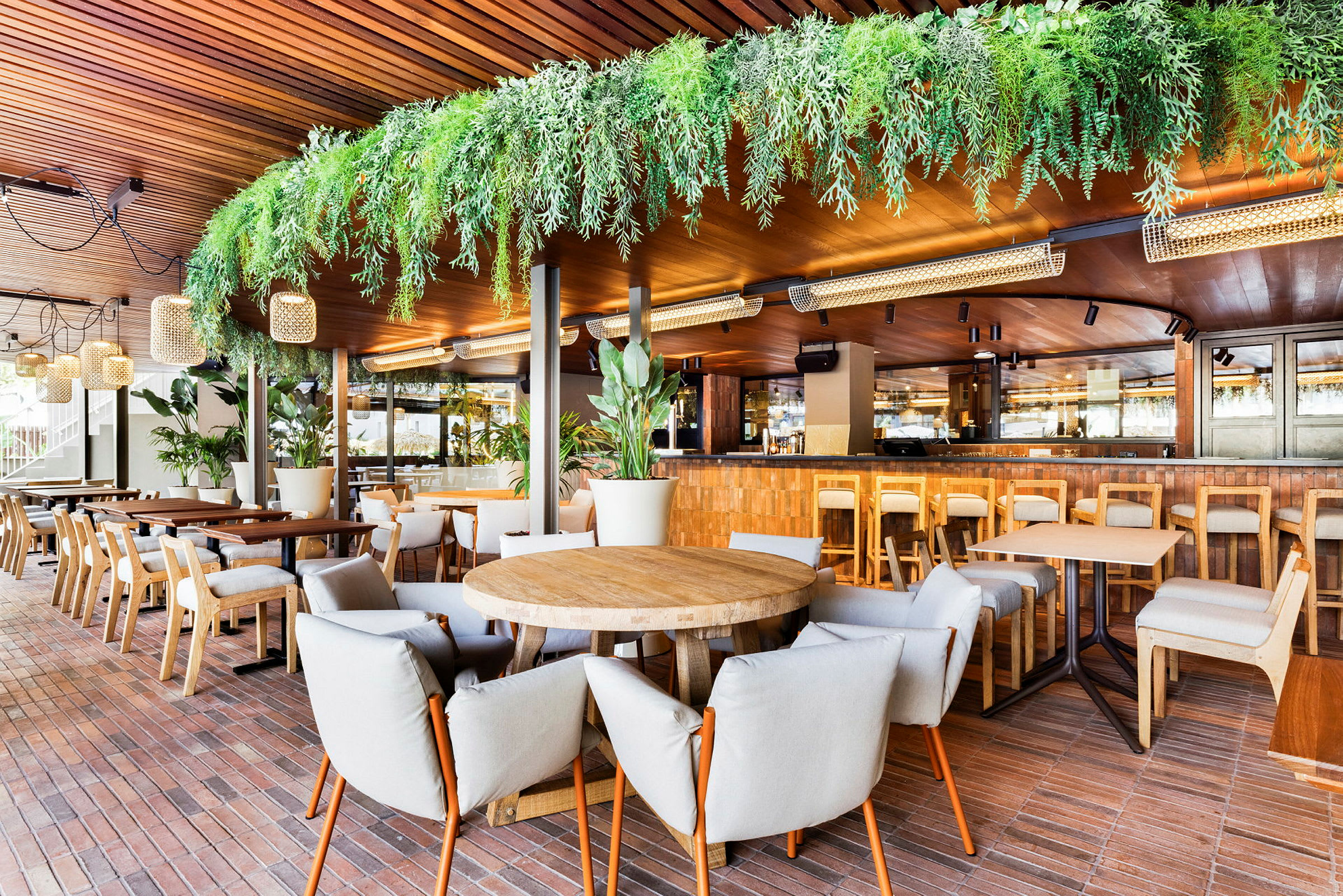 En restaurang med träinteriör, sittplatser och grön dekoration. (AI-genererad text)