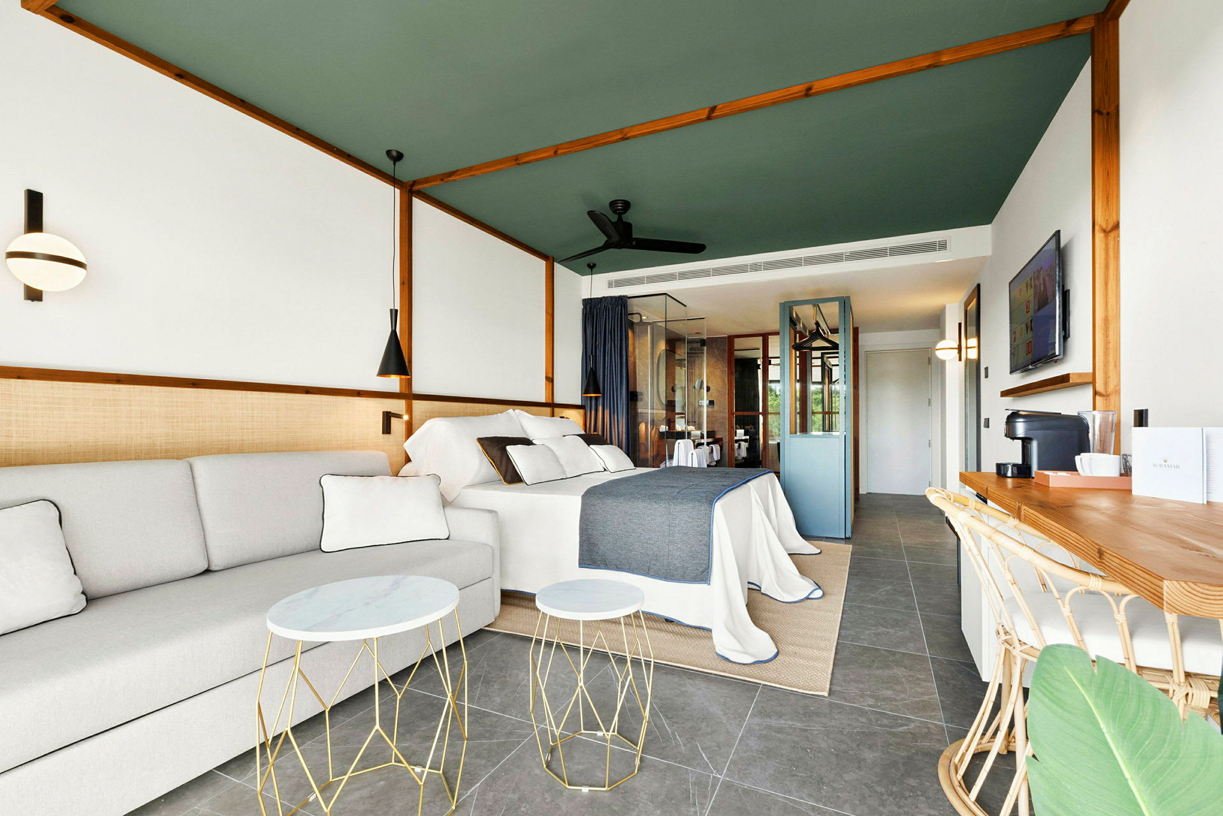 Modernt inrett hotellrum med säng, soffa och arbetsyta. (AI-genererad text)