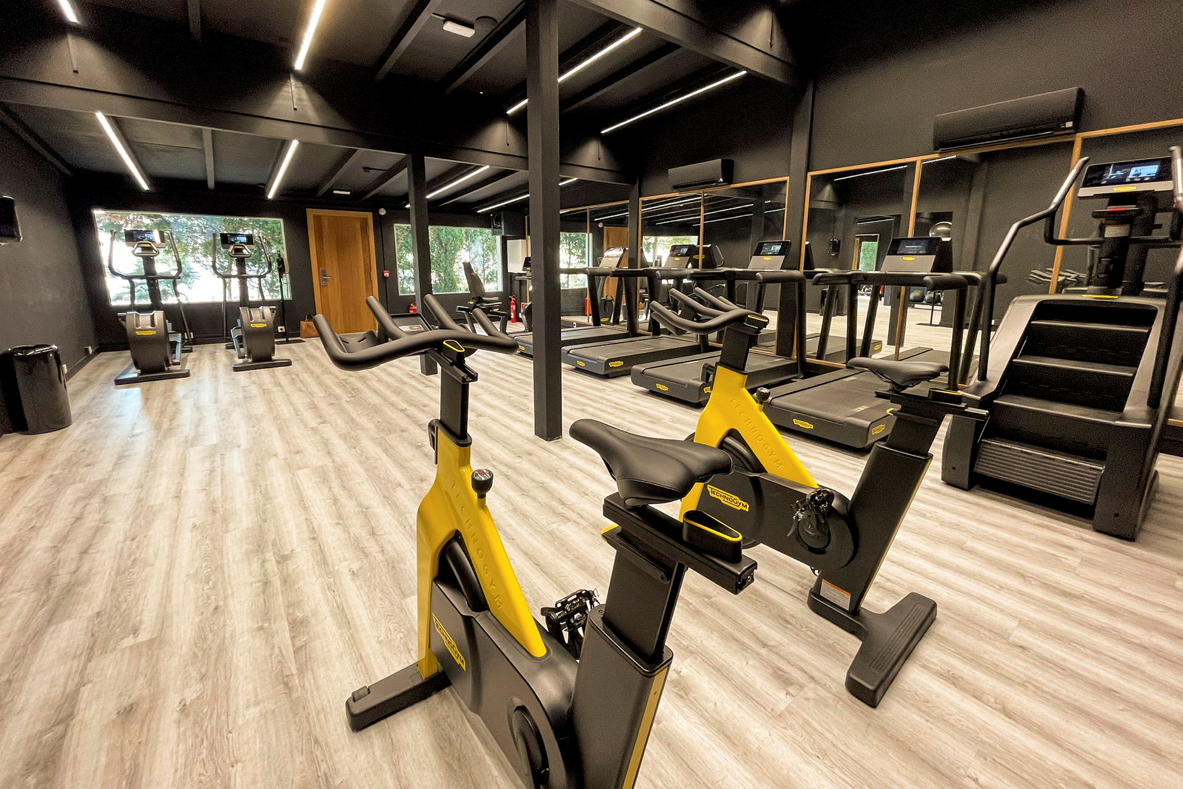 Ett gym med träningsmaskiner såsom löpband, träningscyklar, och trappmaskiner. (AI-genererad text)