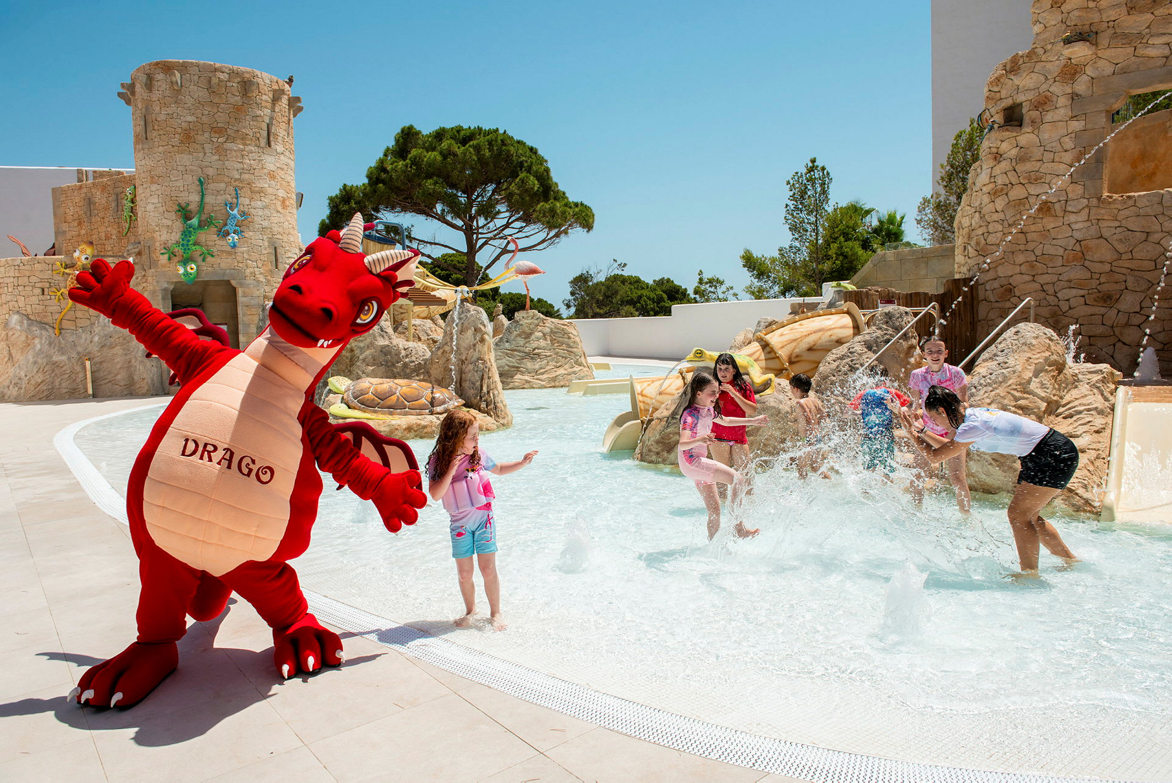 En karaktär i form av en röd drake står bredvid ett vattenområde och leker nära en pool. (AI-genererad text)