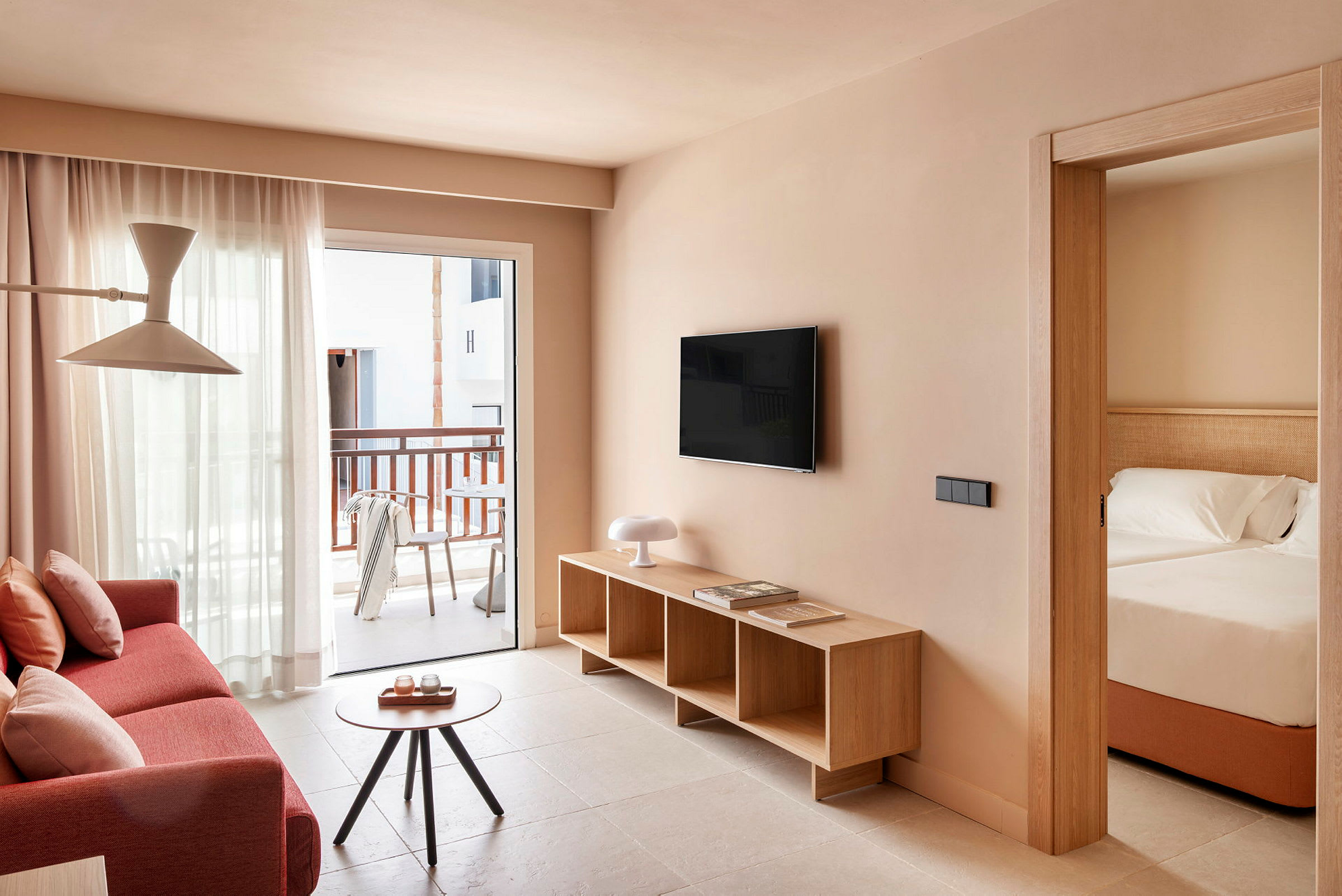 En ljus och modern hotellrumsvit med vardagsrum och anslutande sovrum. (AI-genererad text)
