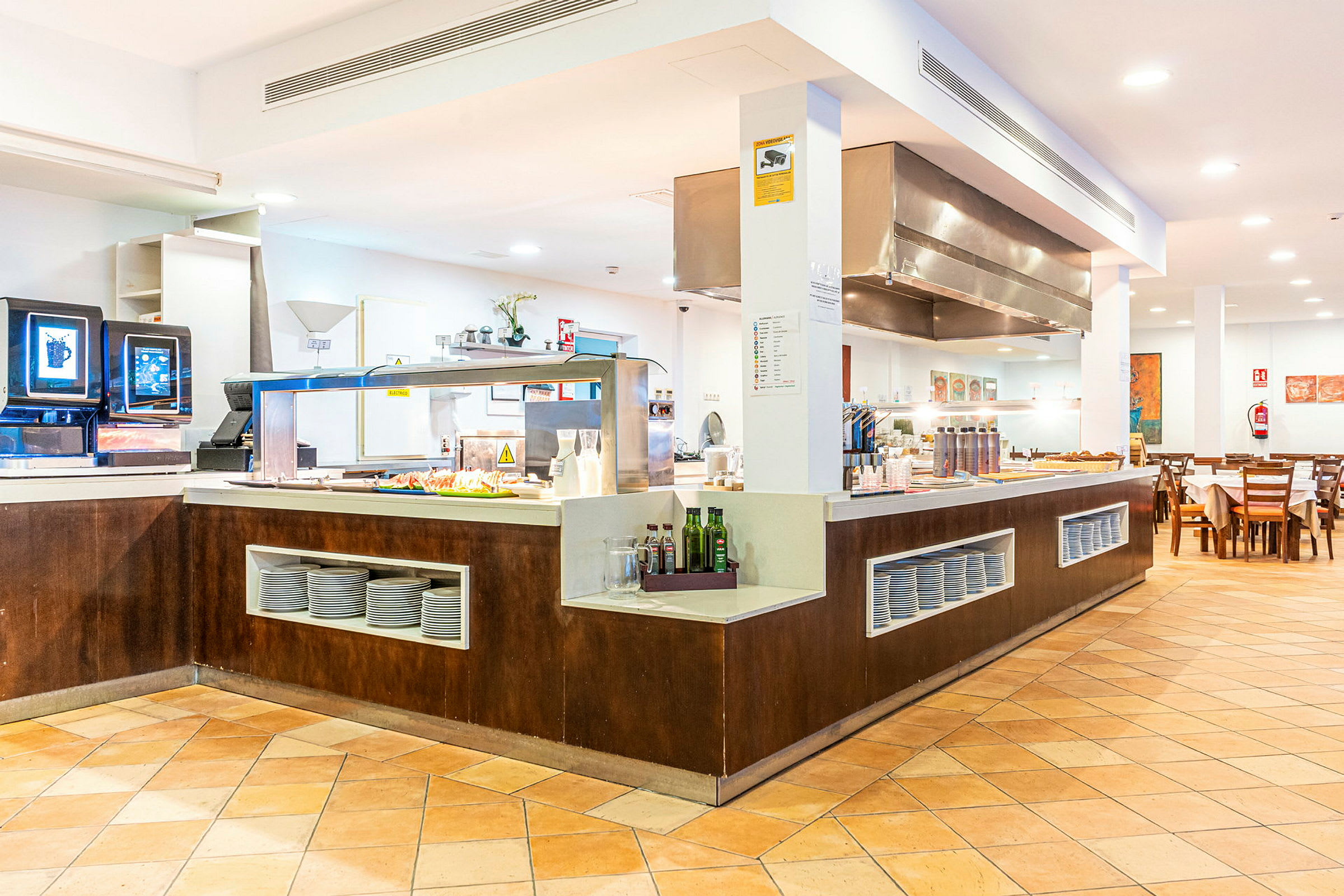 Ett bufféområde i en restaurang med matservering och sittplatser. (AI-genererad text)