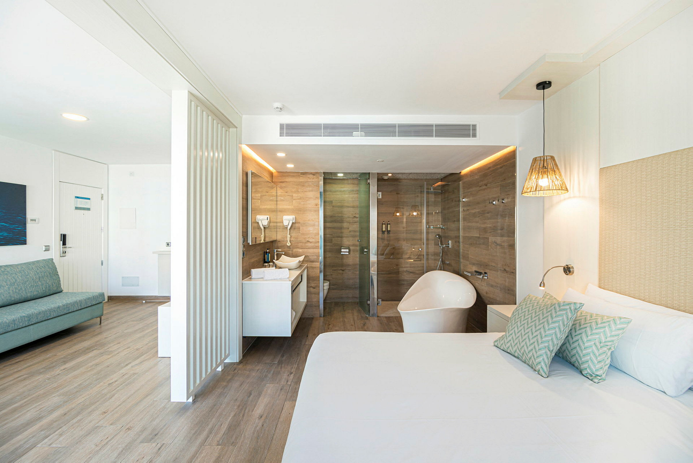 Ett ljust hotellrum med badkar och dusch i anslutning. (AI-genererad text)