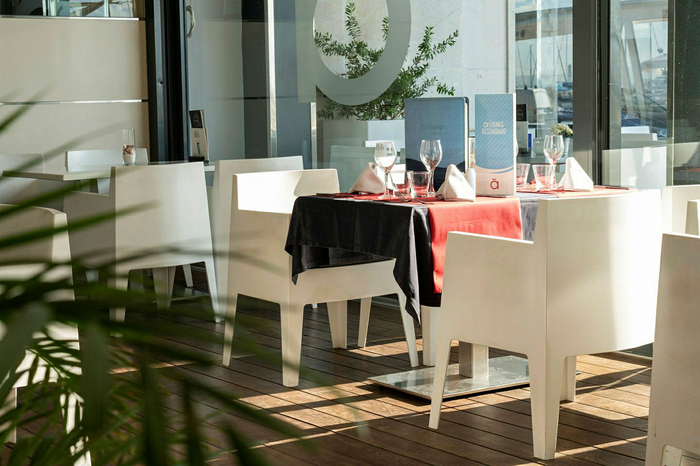 Ett bord i en restaurang med vit inredning och röd duk. (AI-genererad text)