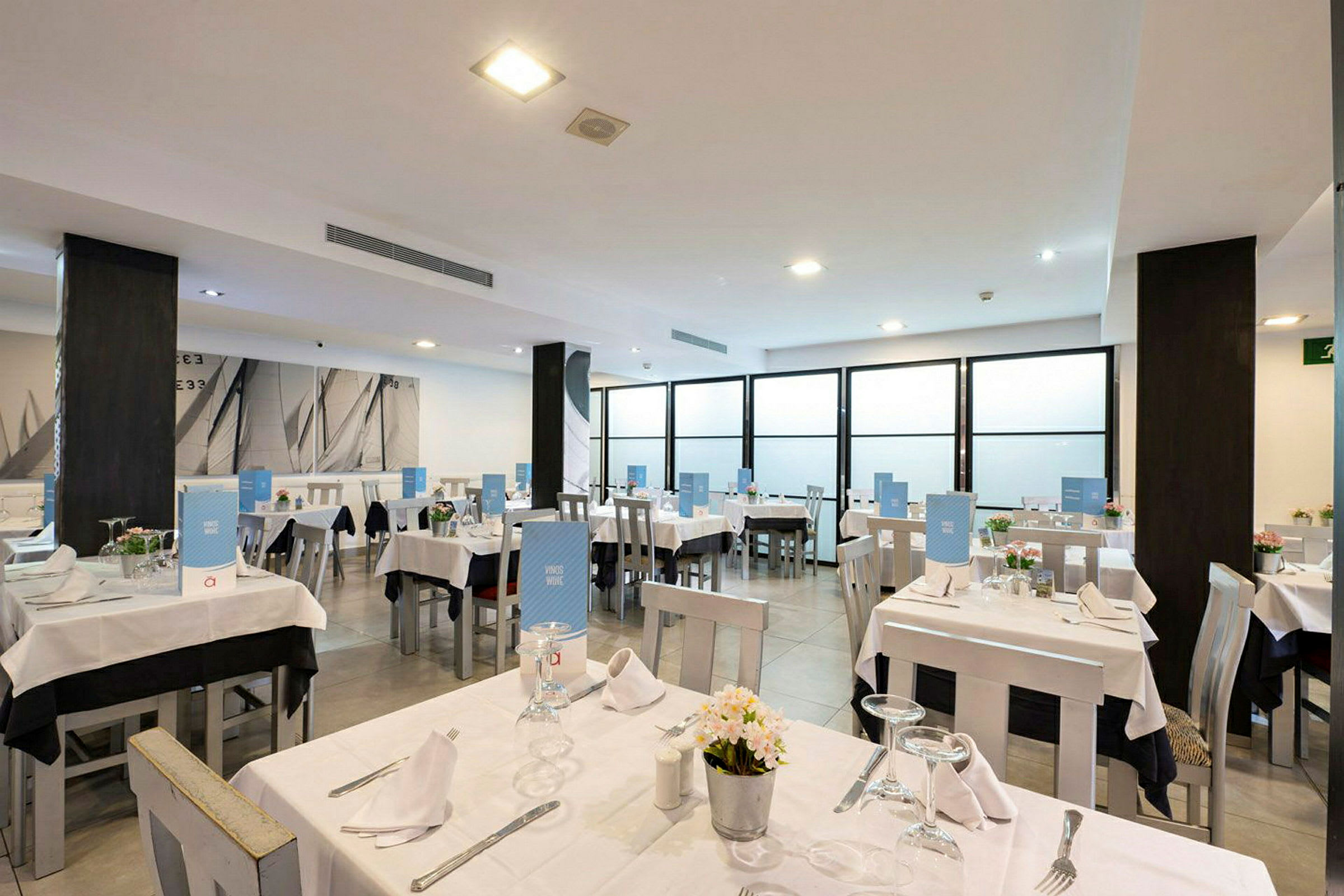 En restaurang med dukade bord och blå menyer. (AI-genererad text)