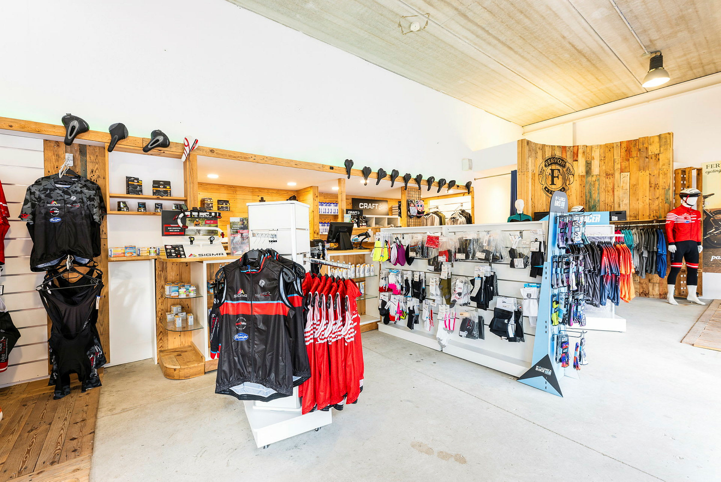 En interiör av en butik som säljer cyklar och cykelutrustning, med kläder och tillbehör på display. (AI-genererad text)