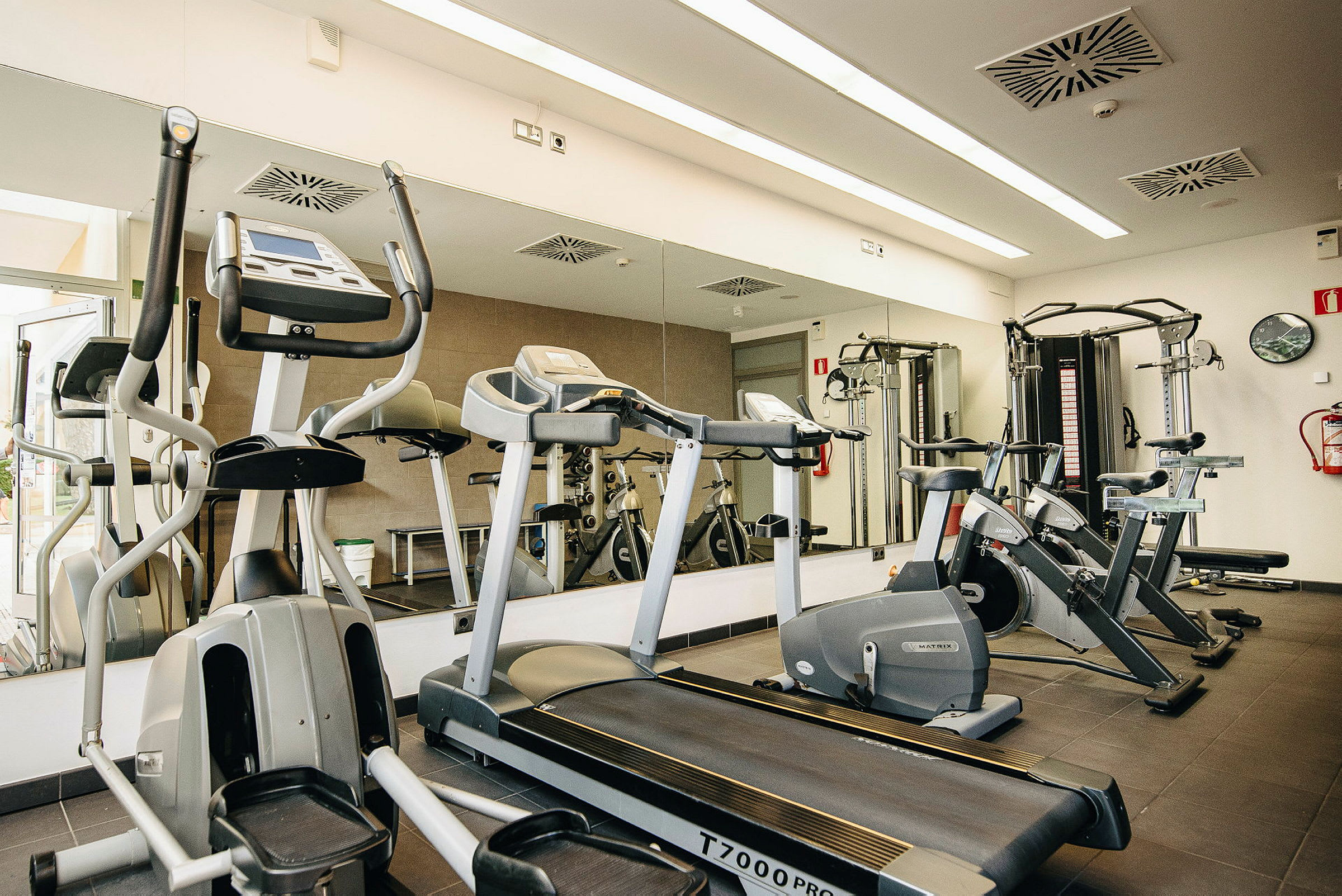 Bild av ett gym med träningsmaskiner som löpband, cyklar och viktmaskiner. (AI-genererad text)