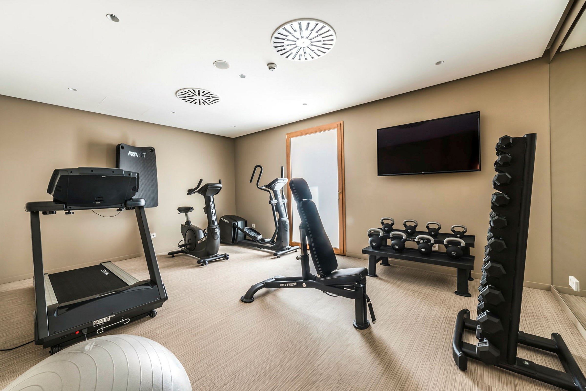Ett gymrum med träningsmaskiner, hantlar och kettlebells. (AI-genererad text)