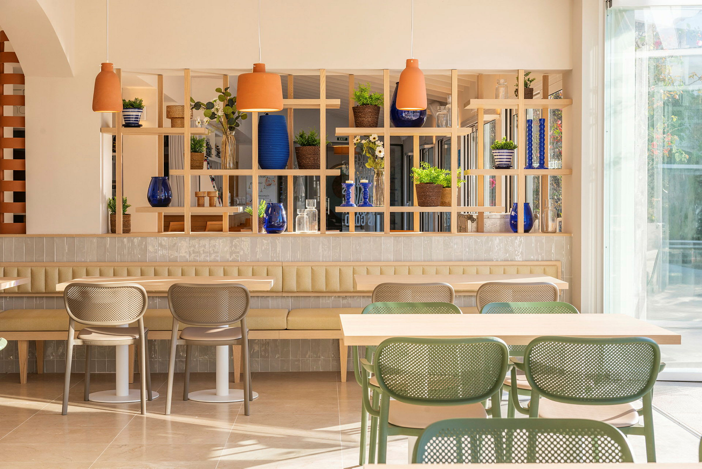 Ett ljust och modernt café med stilfulla möbler och gröna växter. (AI-genererad text)