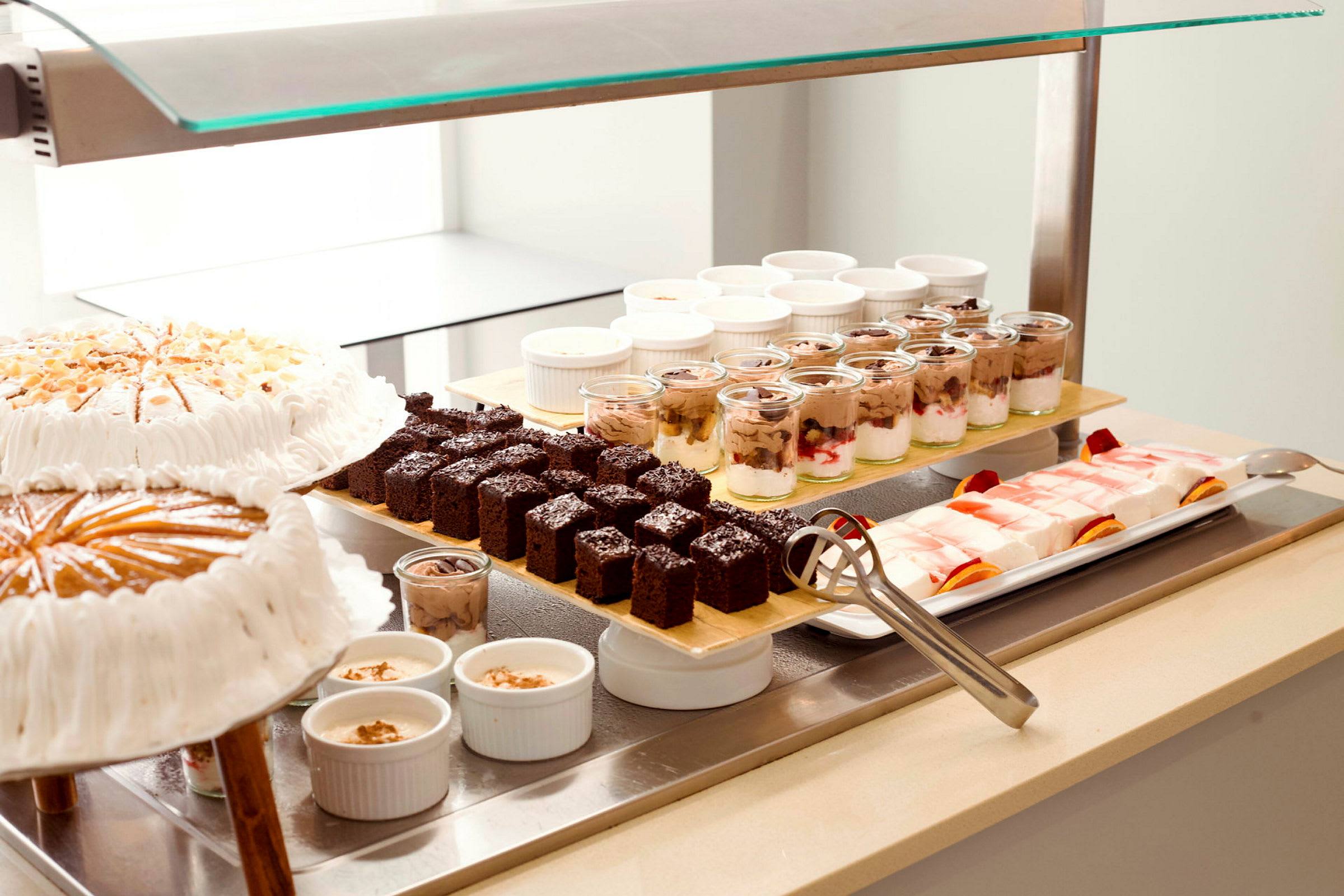 Bild av en buffé med olika desserter, inklusive tårtor, chokladkakor, pudding och gelé. (AI-genererad text)