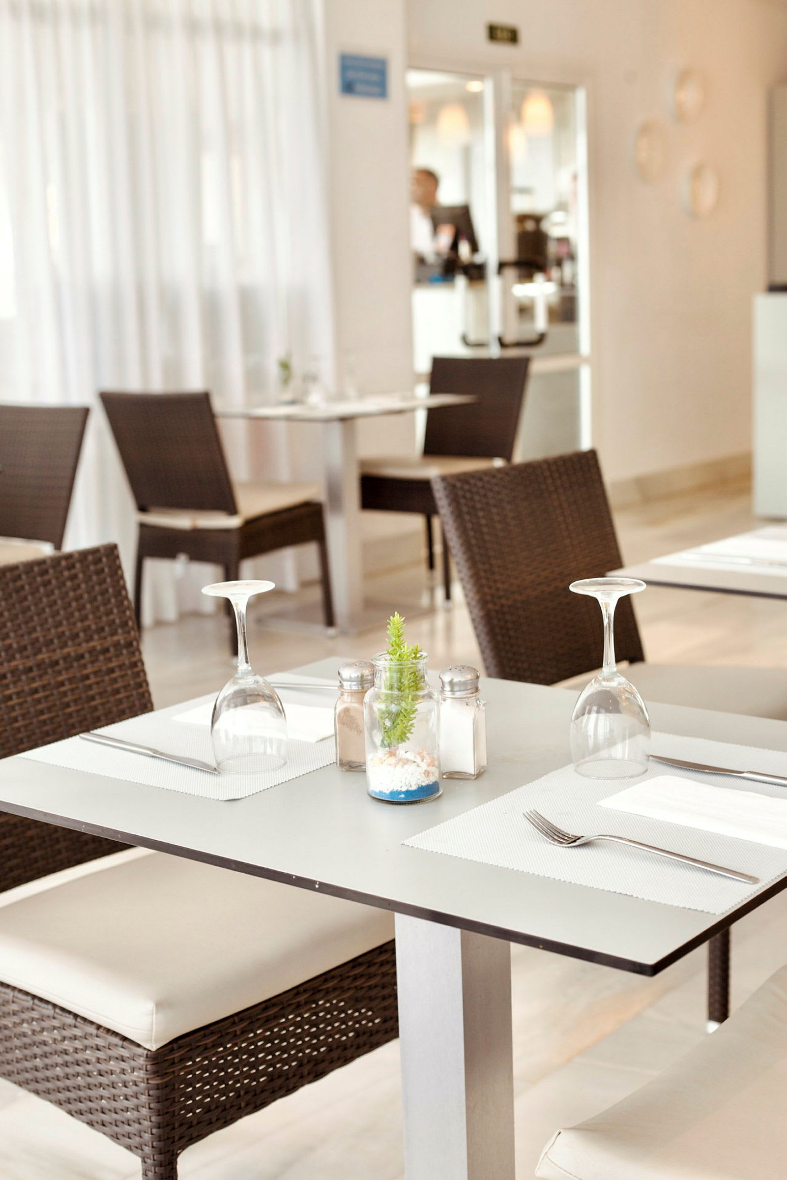 Ett dukat bord med stolar i en restaurang. (AI-genererad text)