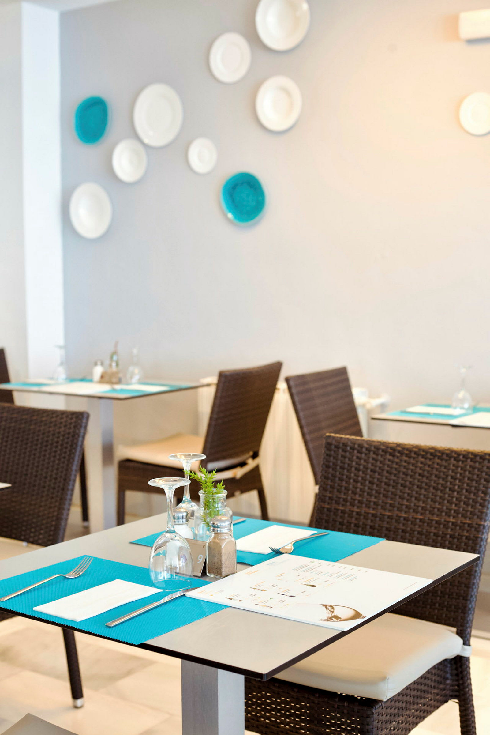 En restaurang med dukade bord och stolar, med dekorationer på väggen. (AI-genererad text)