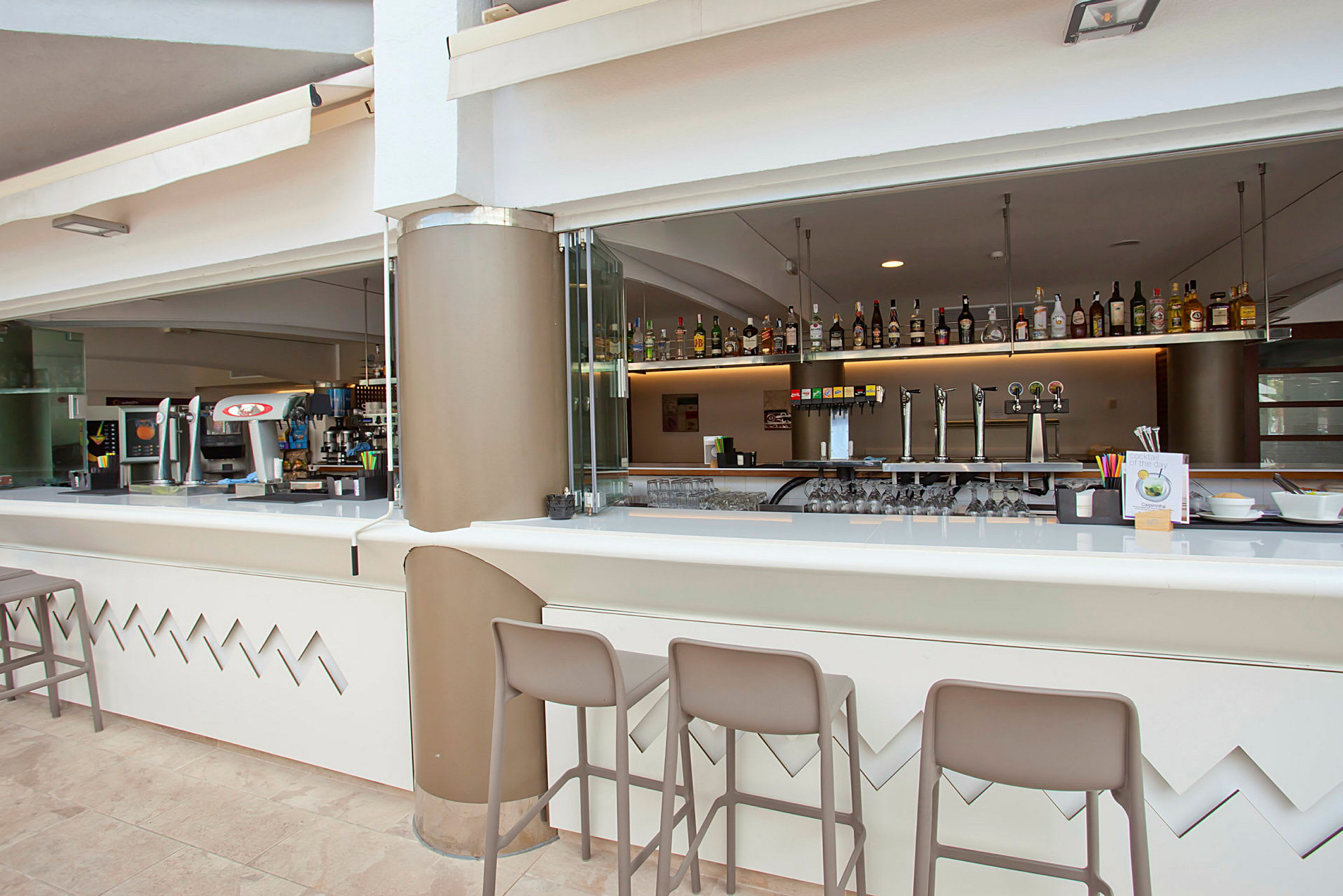 En ljus bar med sittplatser och dryckesvaror synliga. (AI-genererad text)
