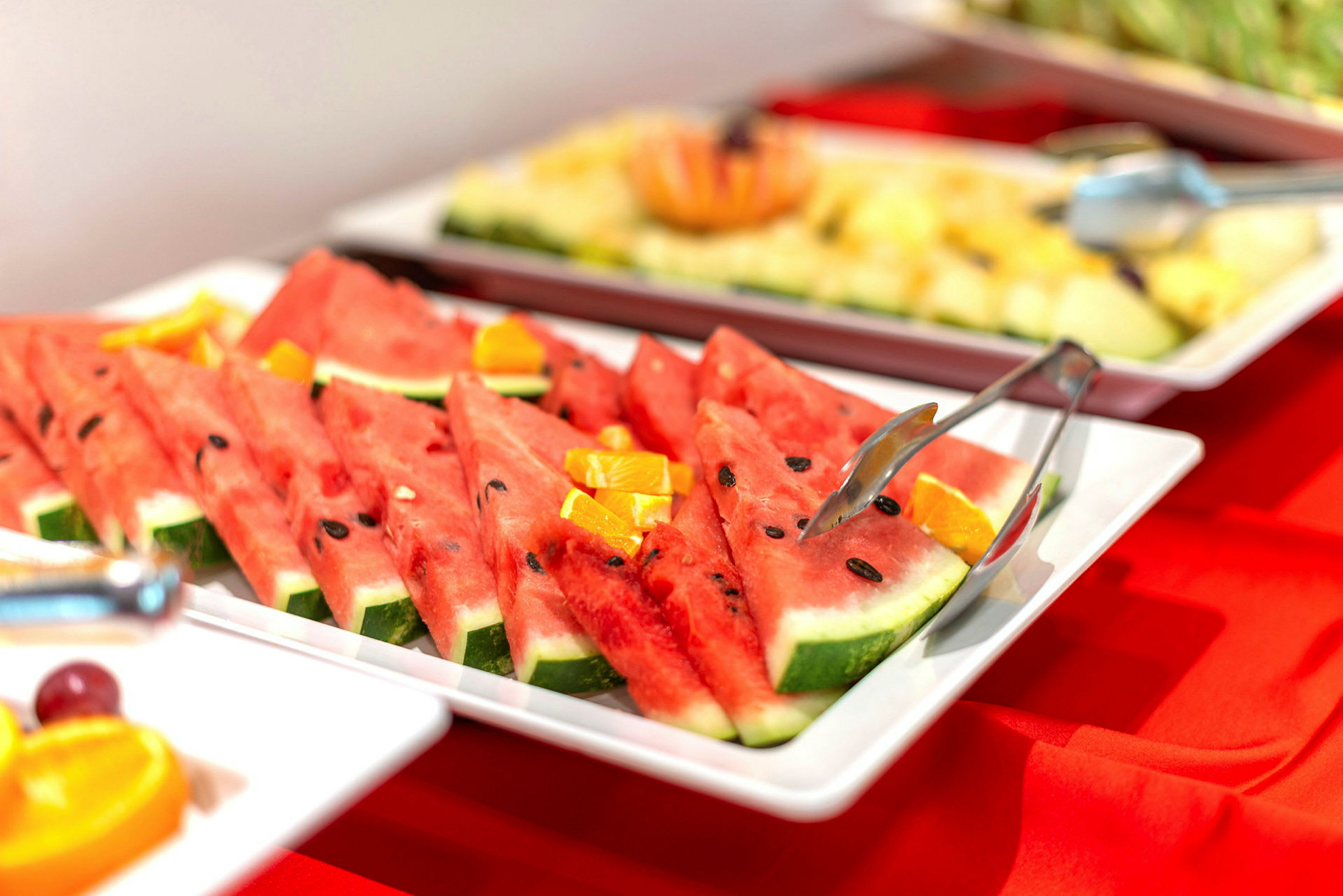 Skivad vattenmelon upplagd på ett vitt fat. (AI-genererad text)