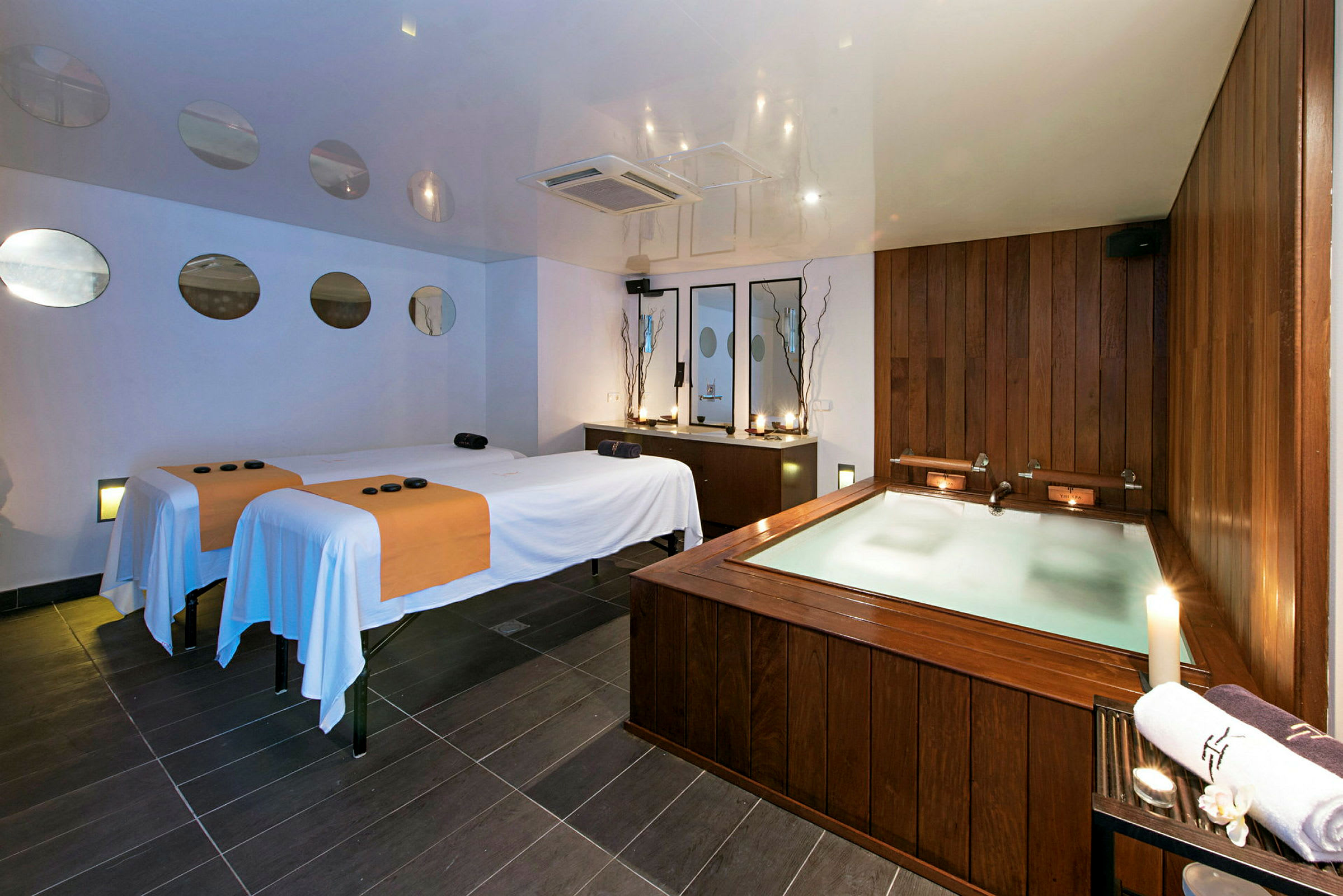 Ett spa-rum med två massagebänkar och en jacuzzi. (AI-genererad text)