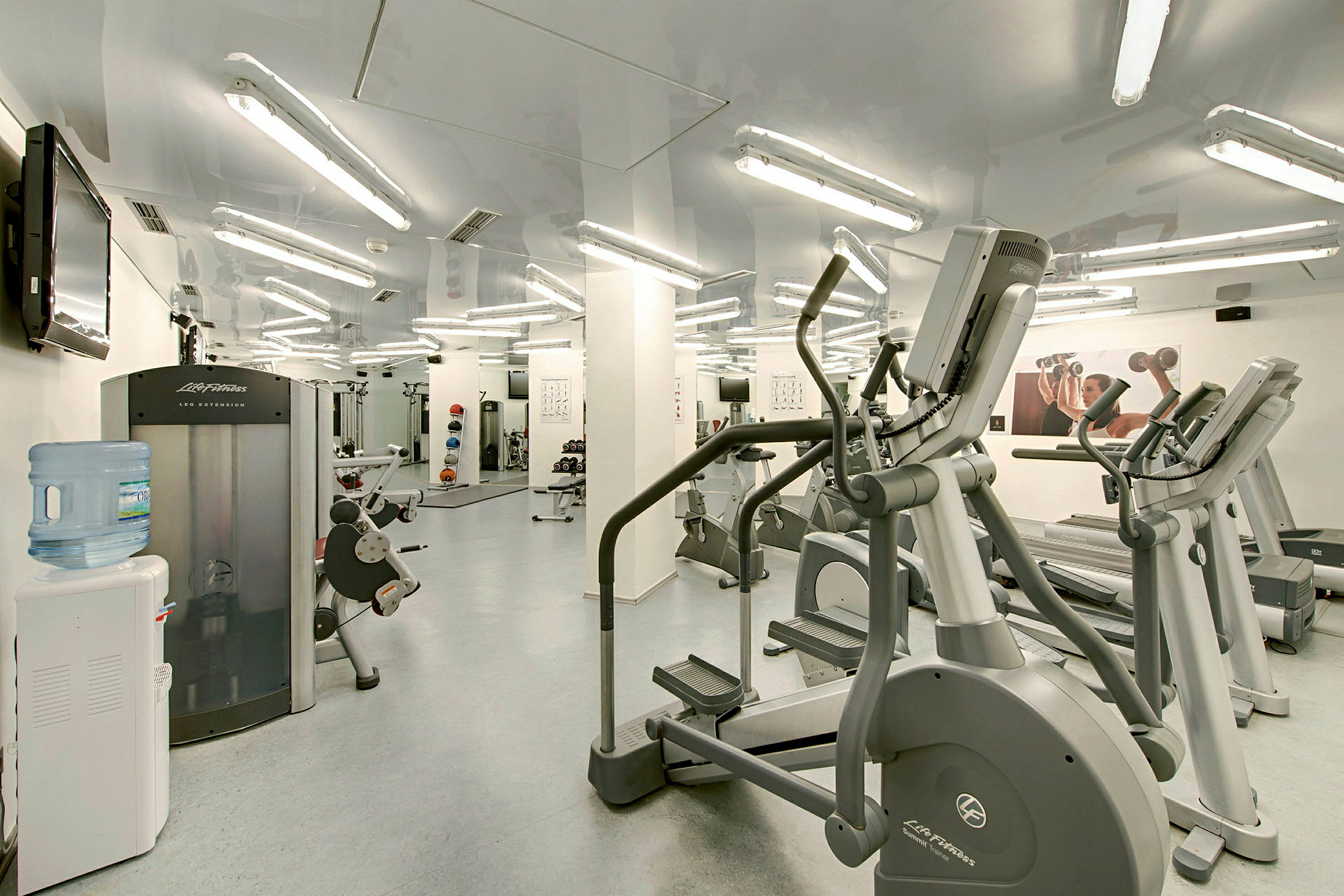 Inomhusgym med träningsmaskiner och fria vikter. (AI-genererad text)