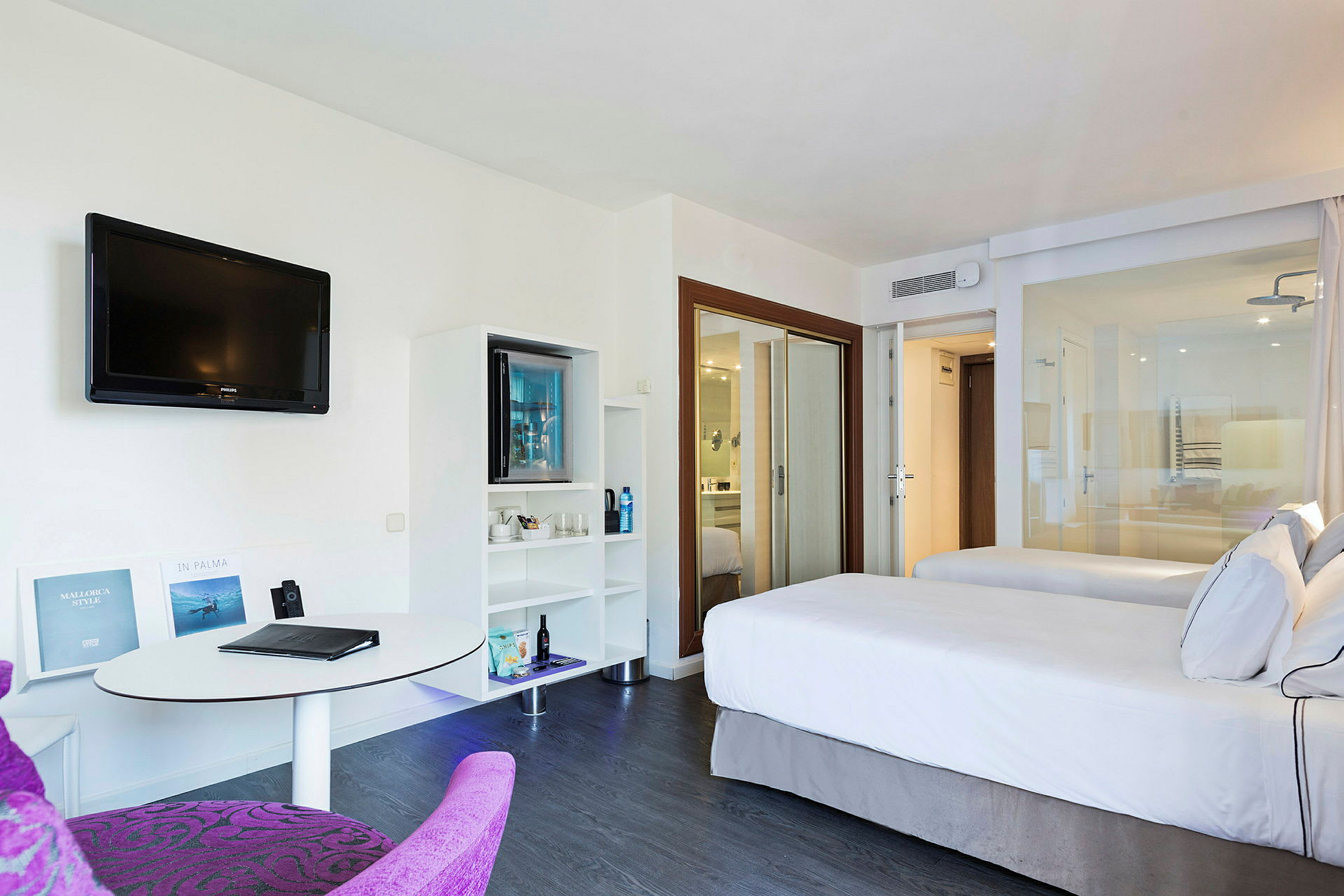 Hotellrum med två sängar, TV på väggen och bord med stol. (AI-genererad text)
