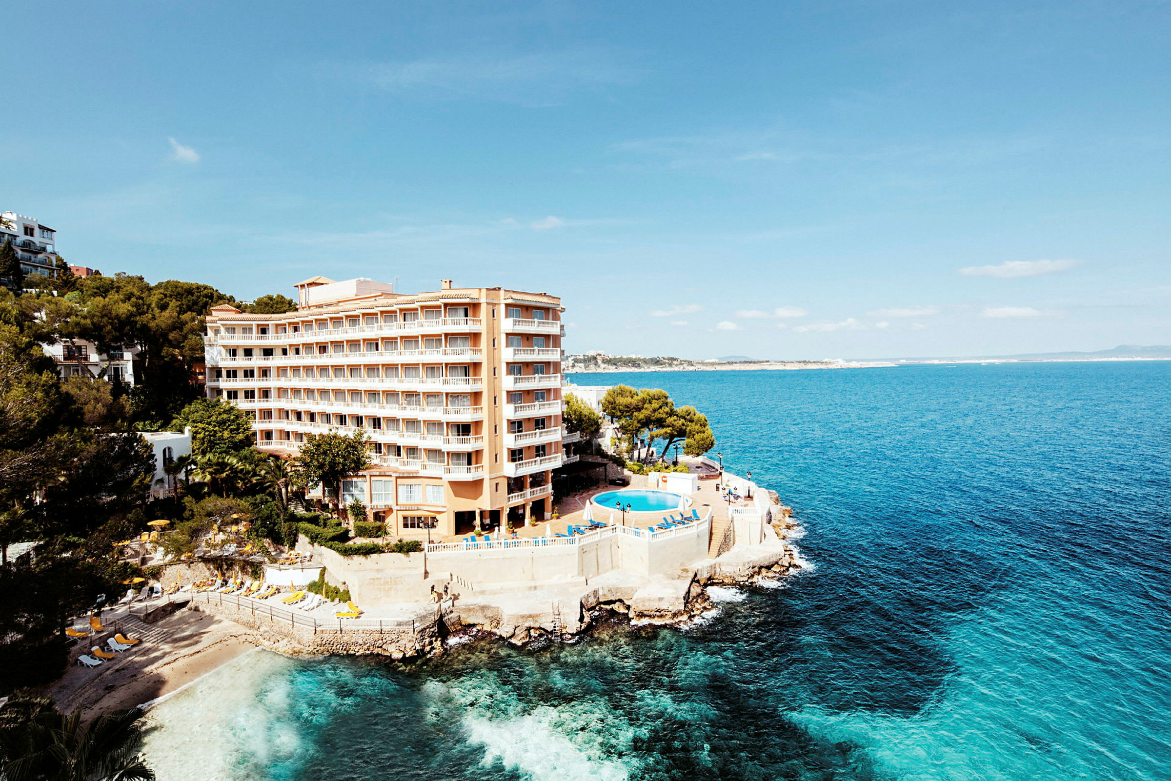 Hotell vid kust med pool och utsikt över havet. (AI-genererad text)