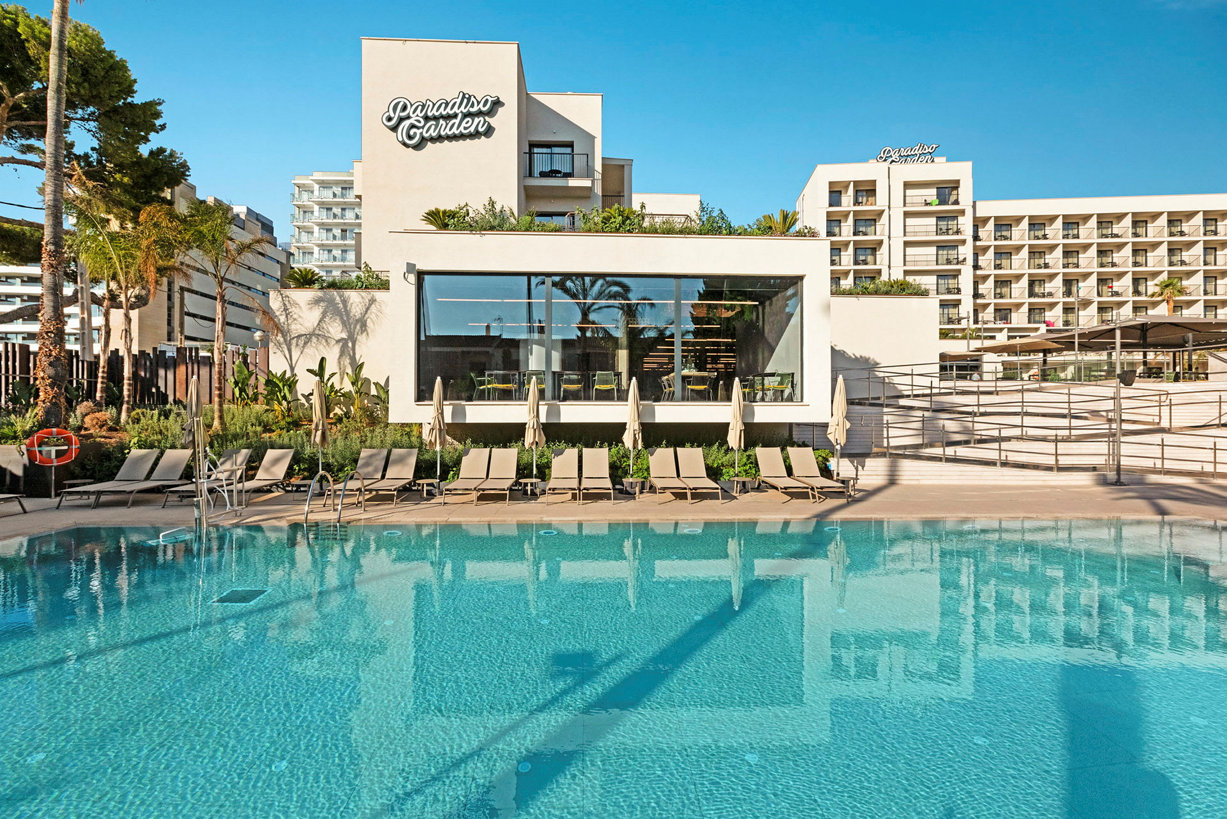 Bild av ett hotell med en pool och solstolar framför byggnaden Paradiso Garden. (AI-genererad text)