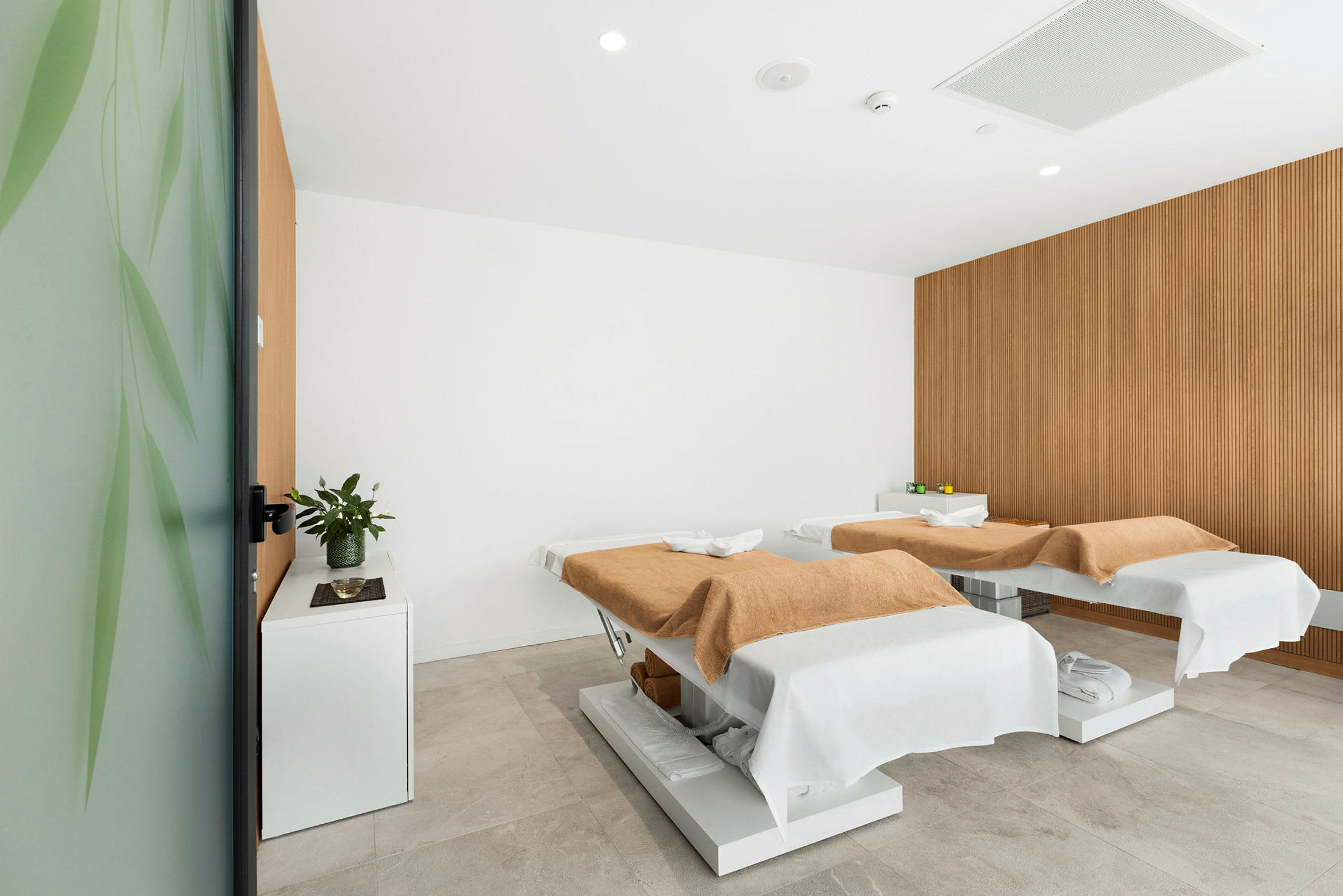 Två massagebänkar i ett modernt behandlingsrum. (AI-genererad text)