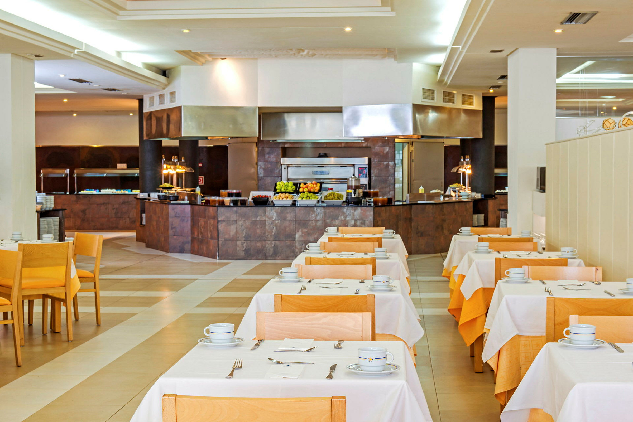 Interiör av en restaurang med dukade bord och serveringsområde i bakgrunden. (AI-genererad text)