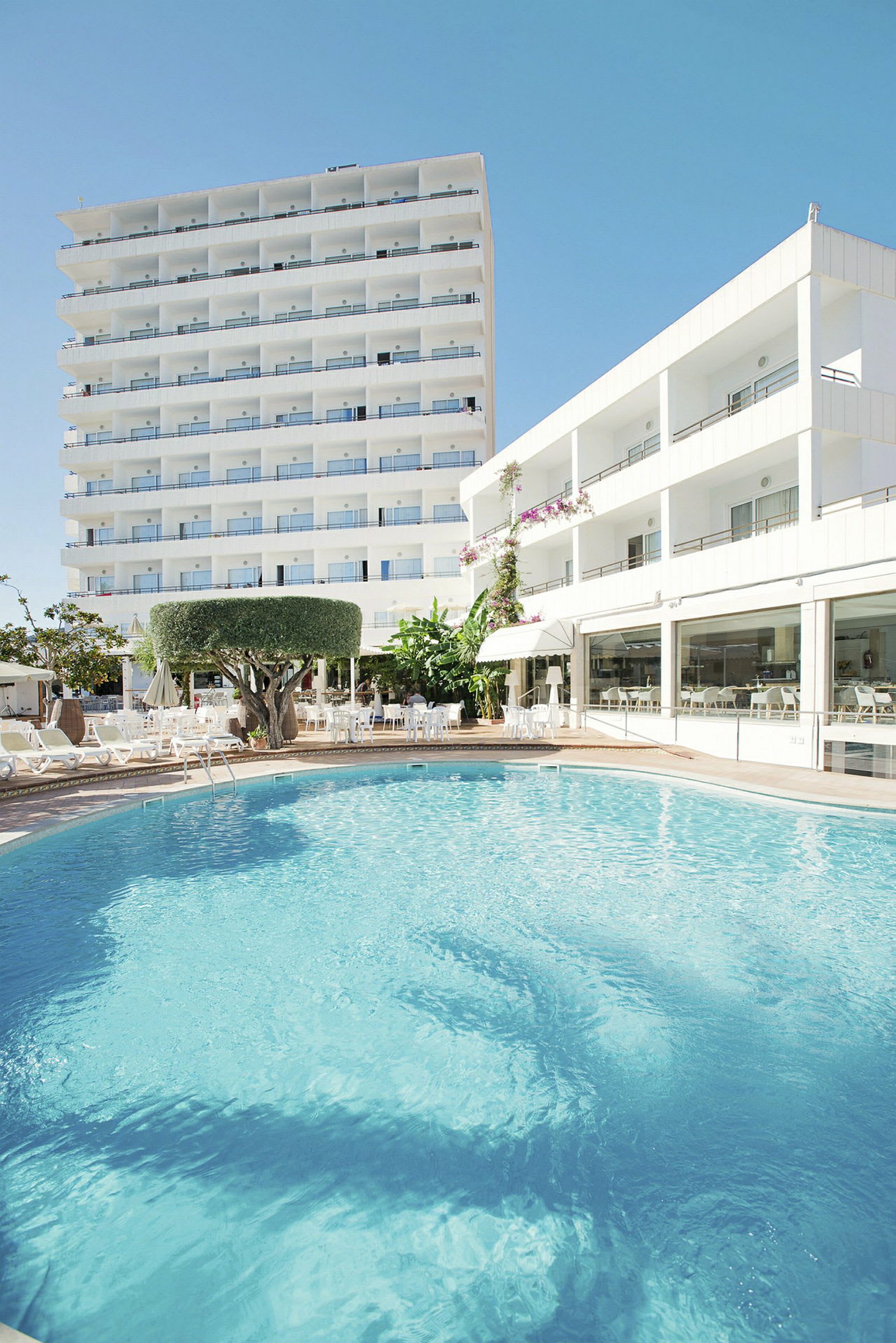 Hotellbyggnader syns kring en utomhuspool. (AI-genererad text)