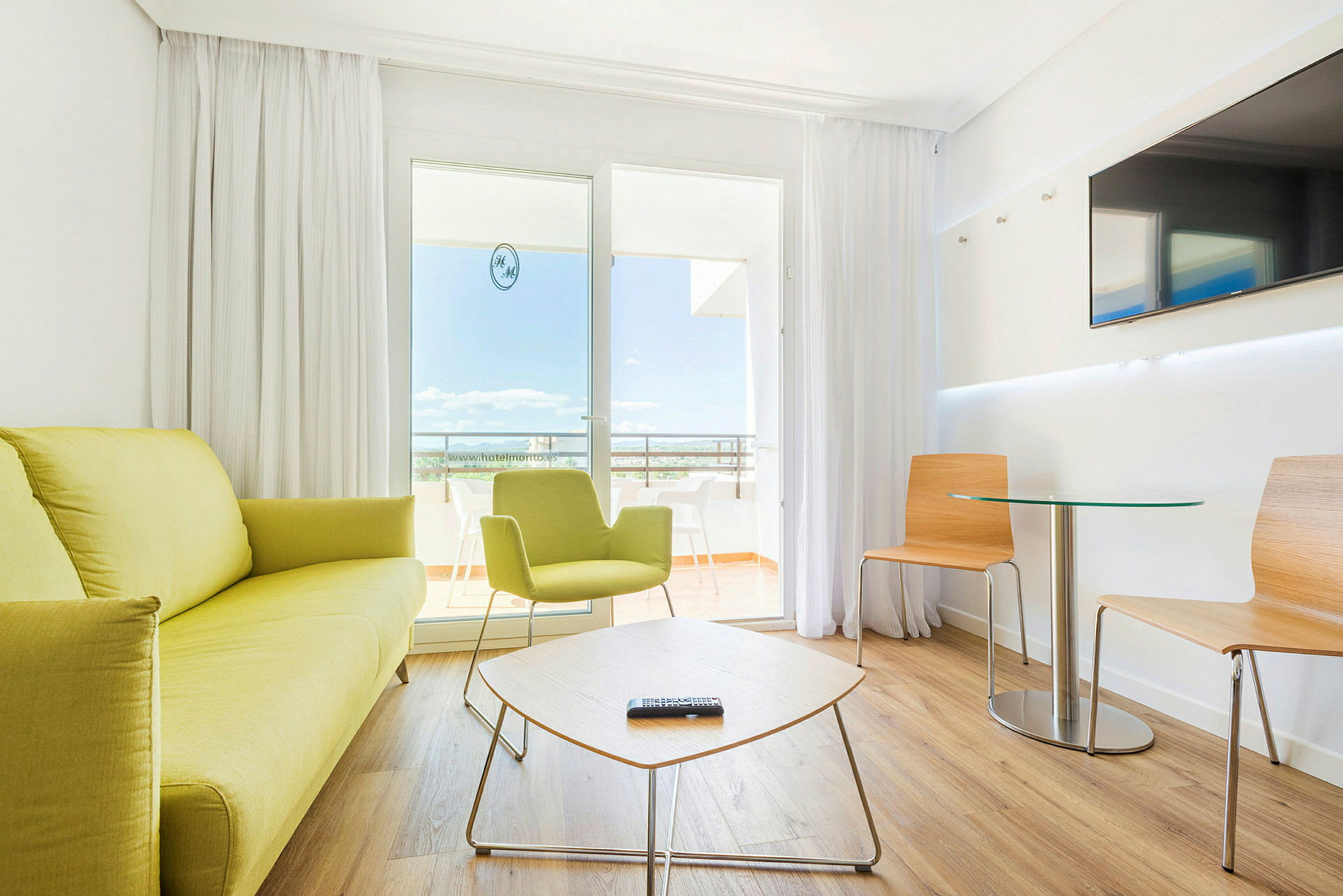 Ett modernt hotellrum med ljusa möbler och sittgrupp. (AI-genererad text)