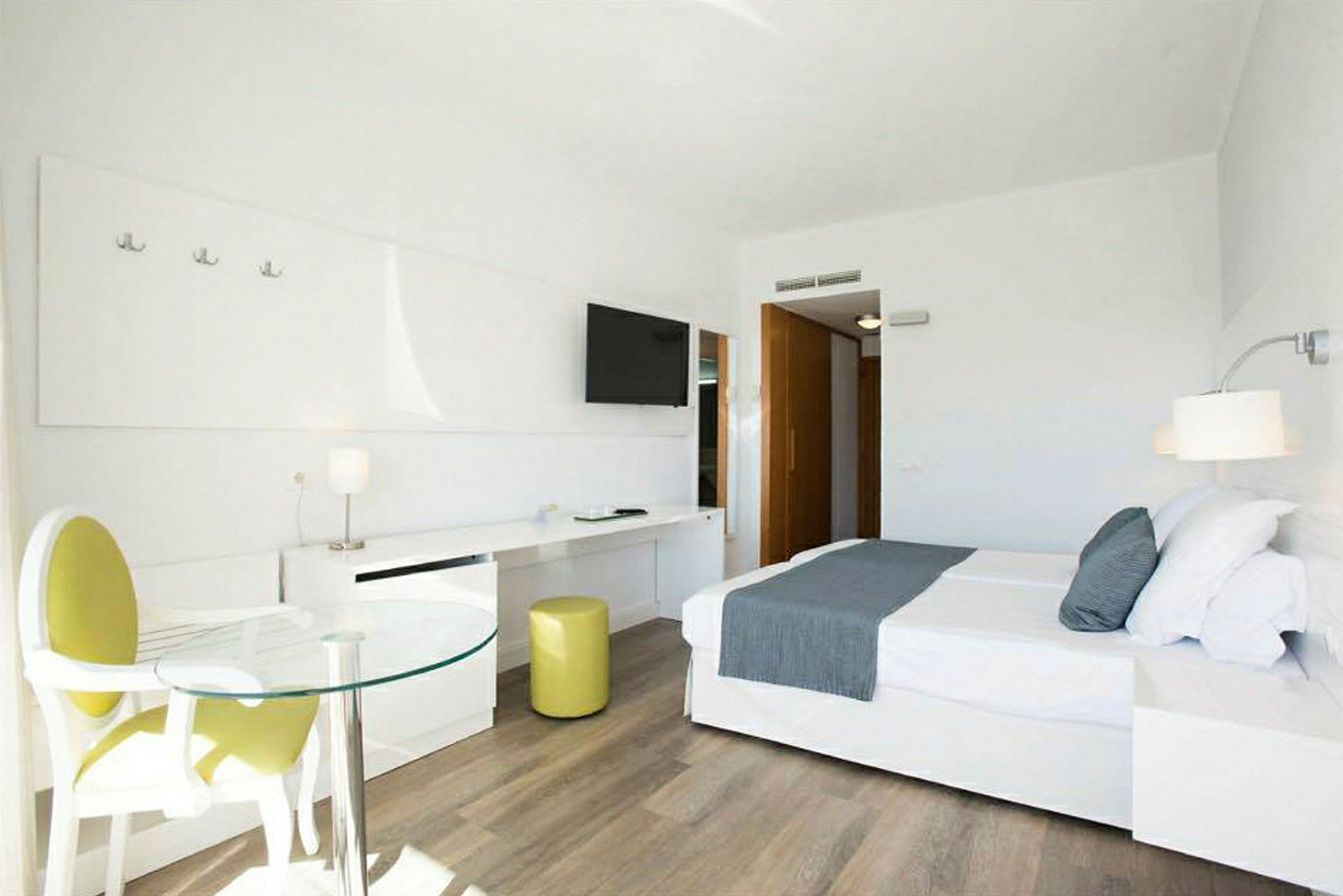 Modernt och ljust hotellrum med en stor säng och sittgrupp. (AI-genererad text)