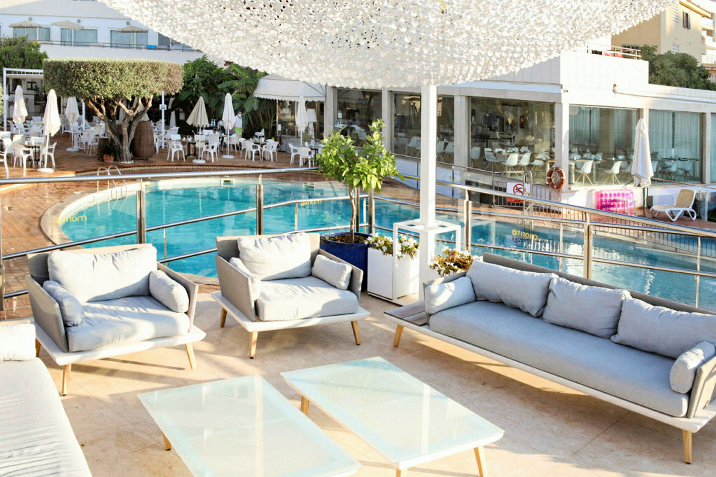 Poolområde med sittgrupp och solstolar. (AI-genererad text)
