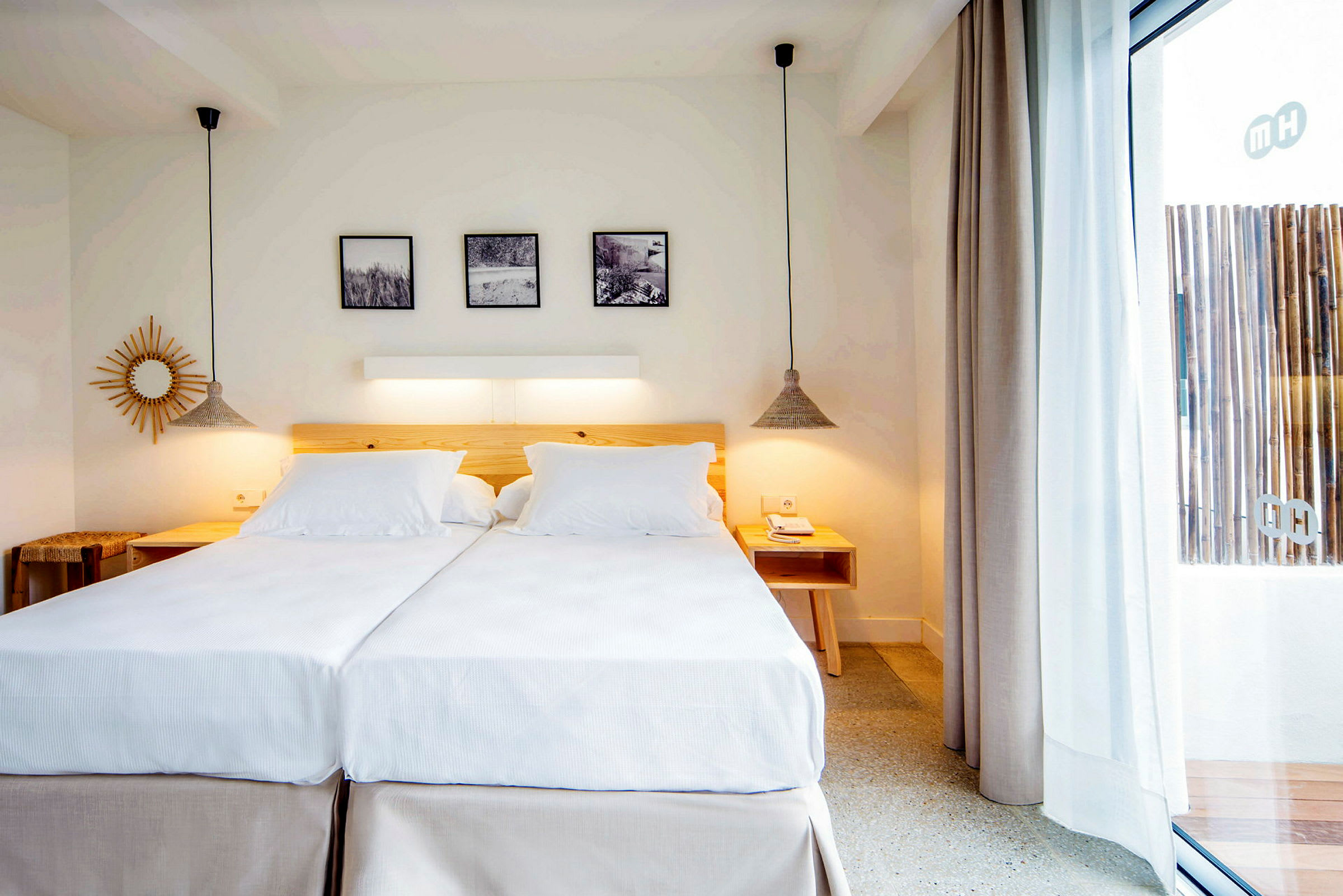 Ett ljust och stilrent inrett hotellrum med två enkelsängar sammansatta till en dubbelsäng, trädetaljer och modern dekoration. (AI-genererad text)