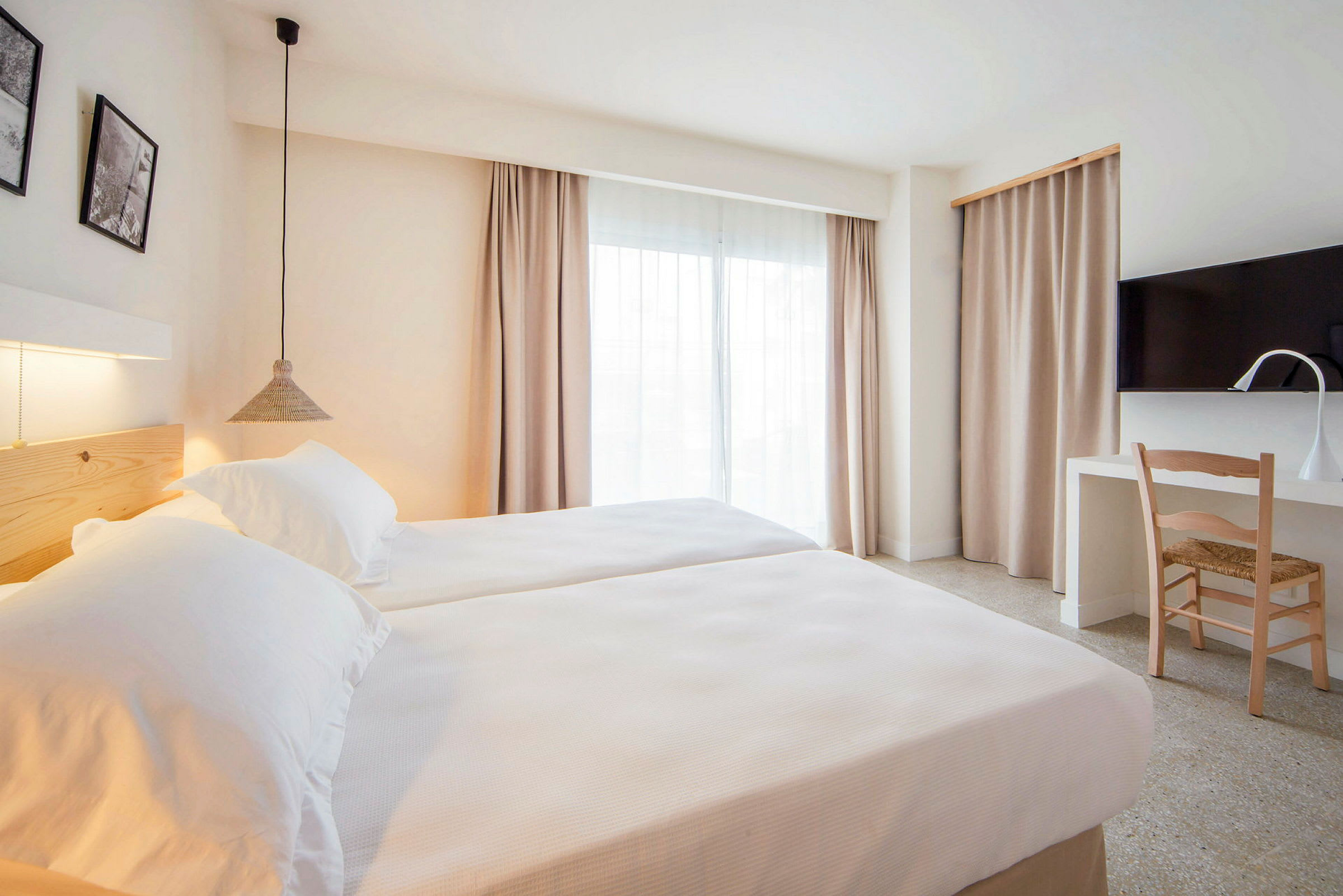 Modernt hotellrum med två enkelsängar, skrivbord och TV. (AI-genererad text)