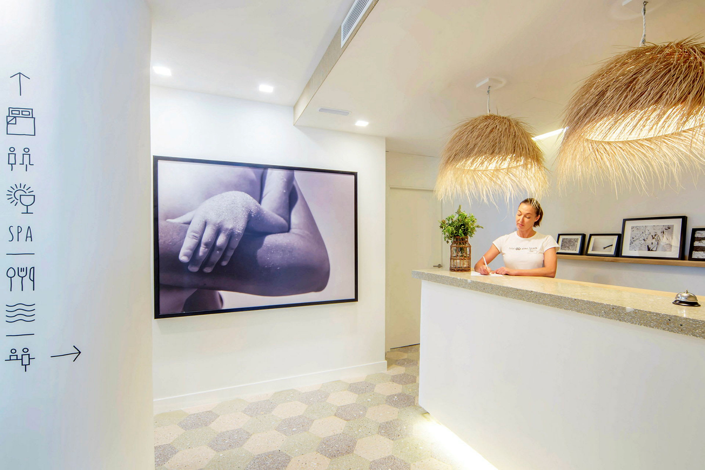 Ljus reception med modern inredning, inklusive en stor fotografisk tavla och dekorativa ljuskällor. (AI-genererad text)