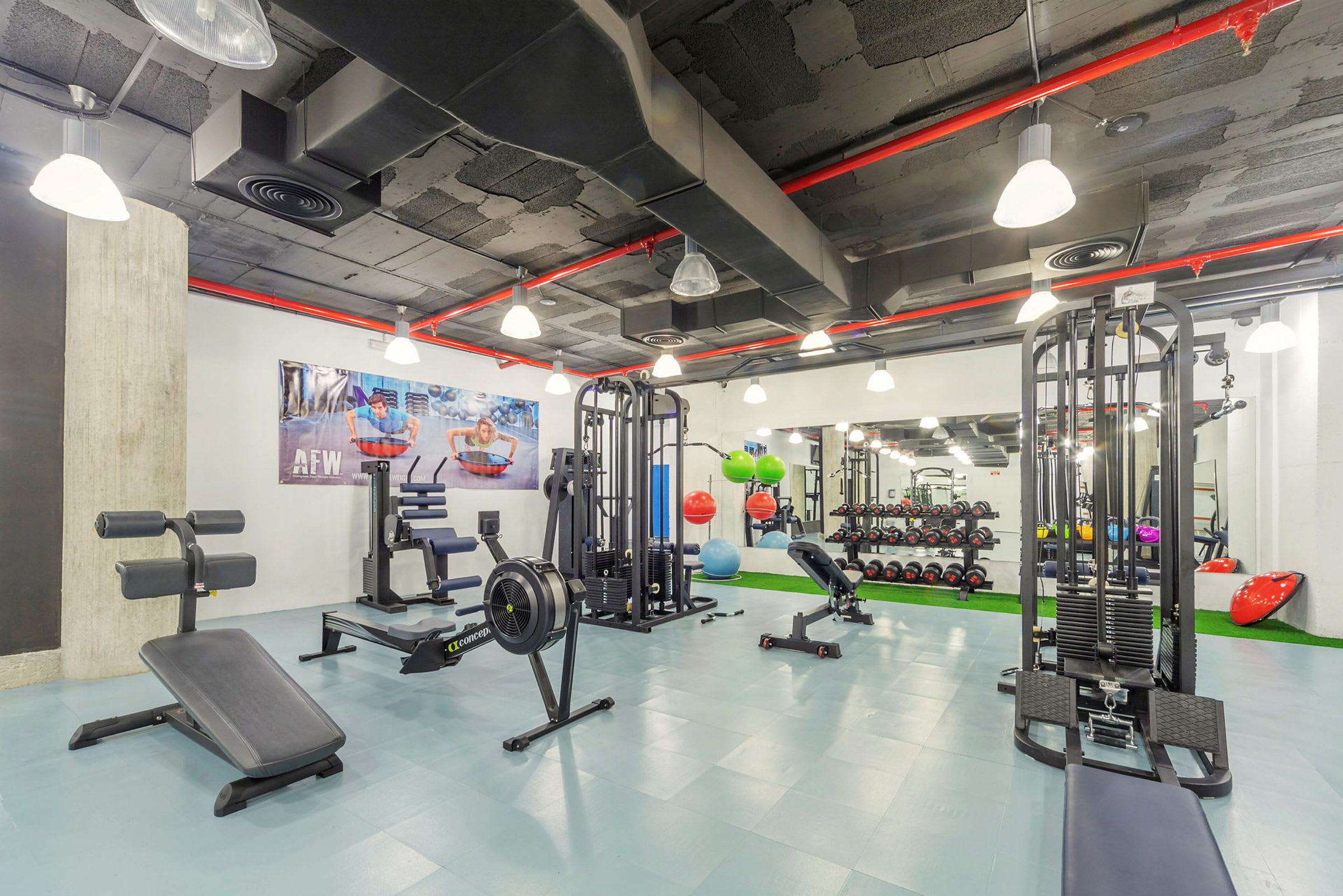 Interiör av ett modernt gym med olika träningsmaskiner och styrketräningsutrustning. (AI-genererad text)