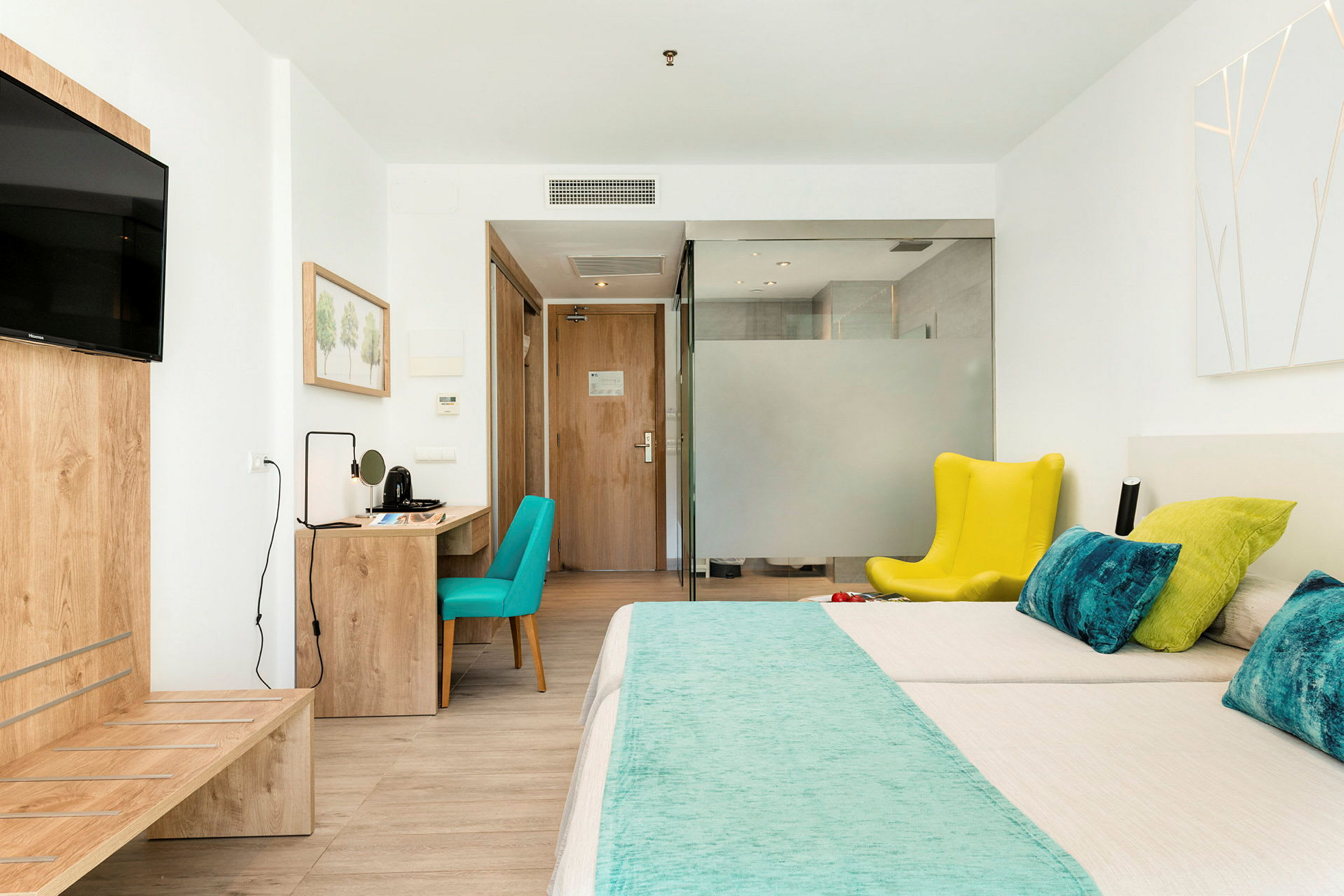 Hotellrum med säng, skrivbord och sittplats. (AI-genererad text)