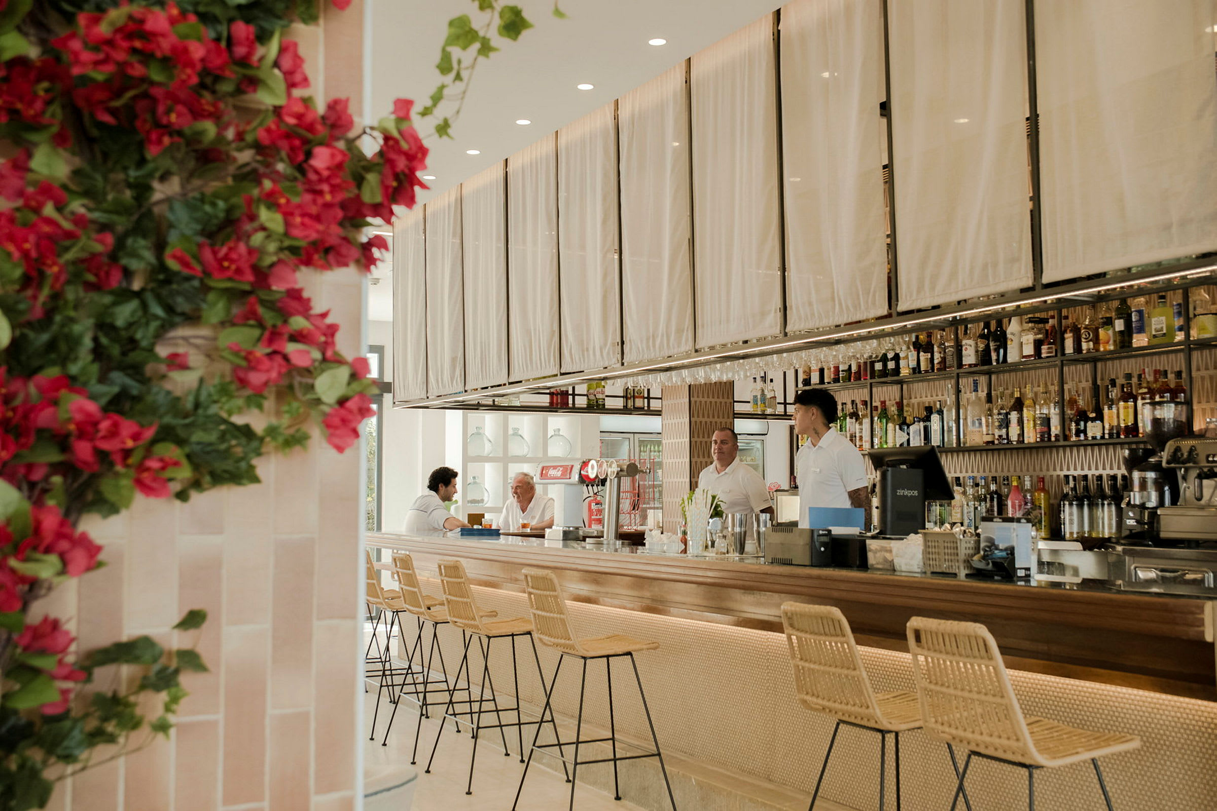Interiör av en modern bar med stilrena möbler och en blombeklätt hörn. (AI-genererad text)